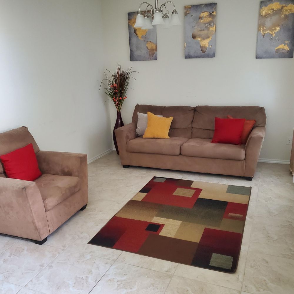 A living room with a couch a chair and a rug