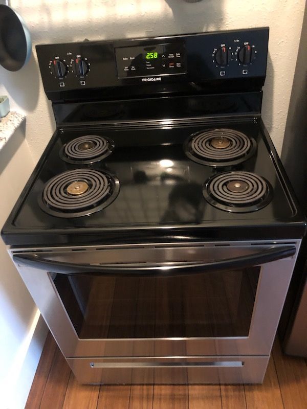 A black stove top oven is sitting on a wooden floor