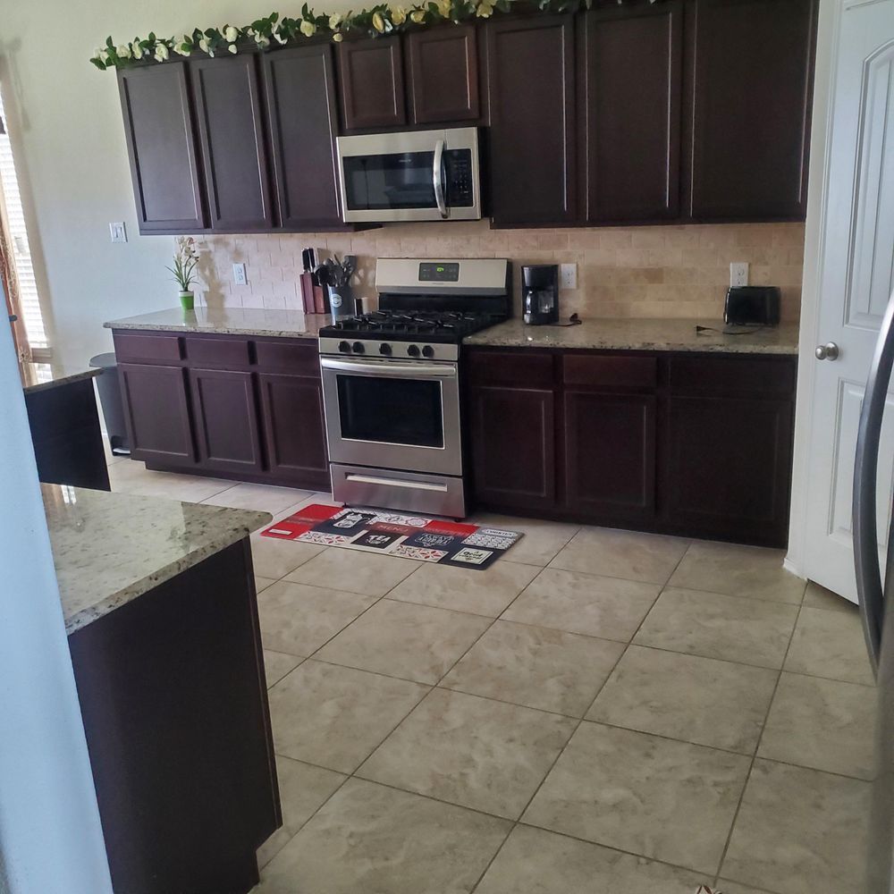A kitchen with stainless steel appliances and brown cabinets