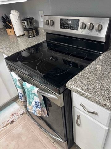 A black stove top oven is sitting on top of a granite counter in a kitchen