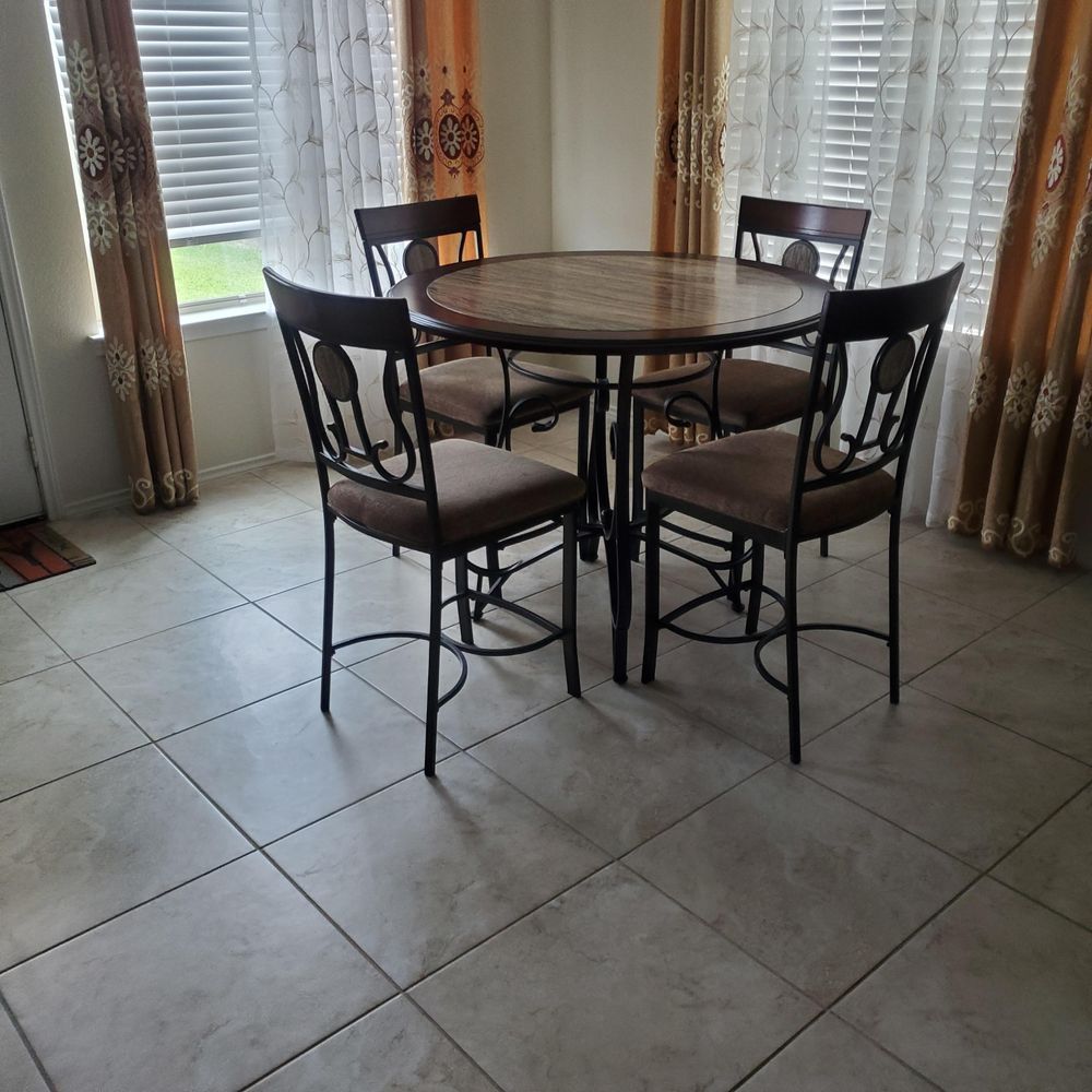 A dining room with a table and chairs in front of a window