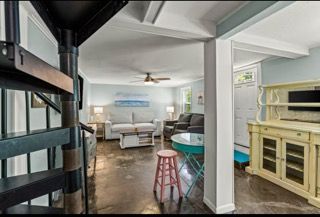 Interior view: Spiral staircase, living room with couches, and a turquoise table.