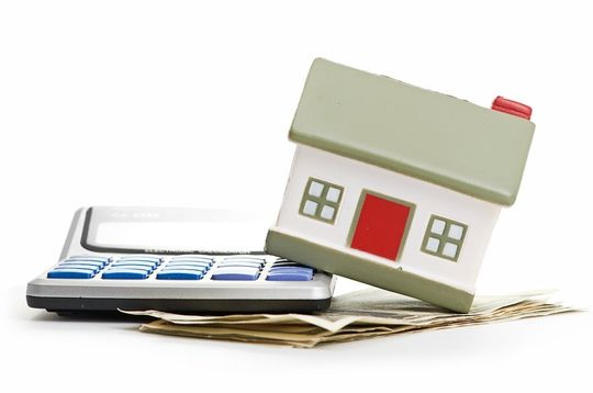 We help figure out the best loan for your mortgage needs house on calculator on pile of money