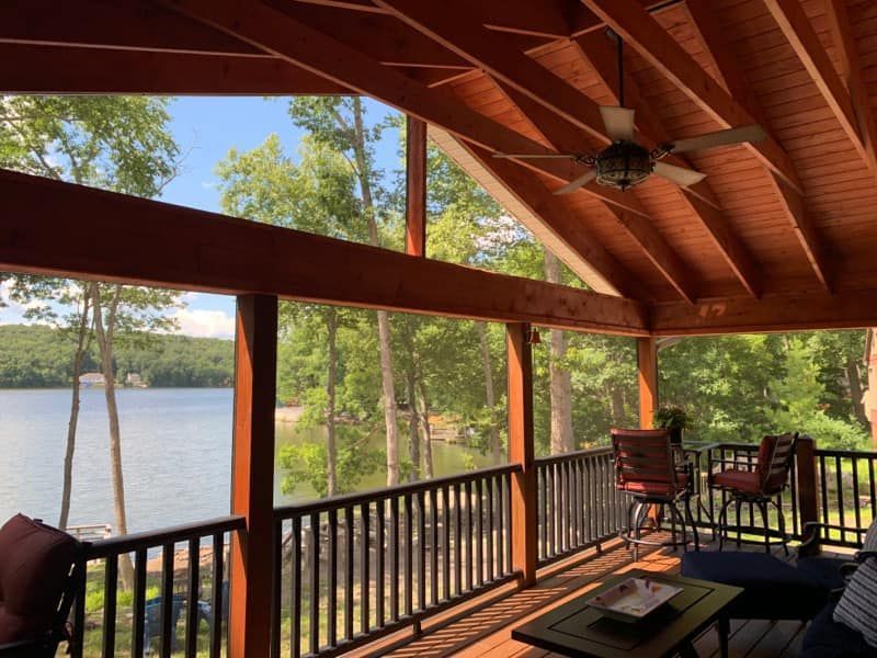A screened in porch with a view of a lake.