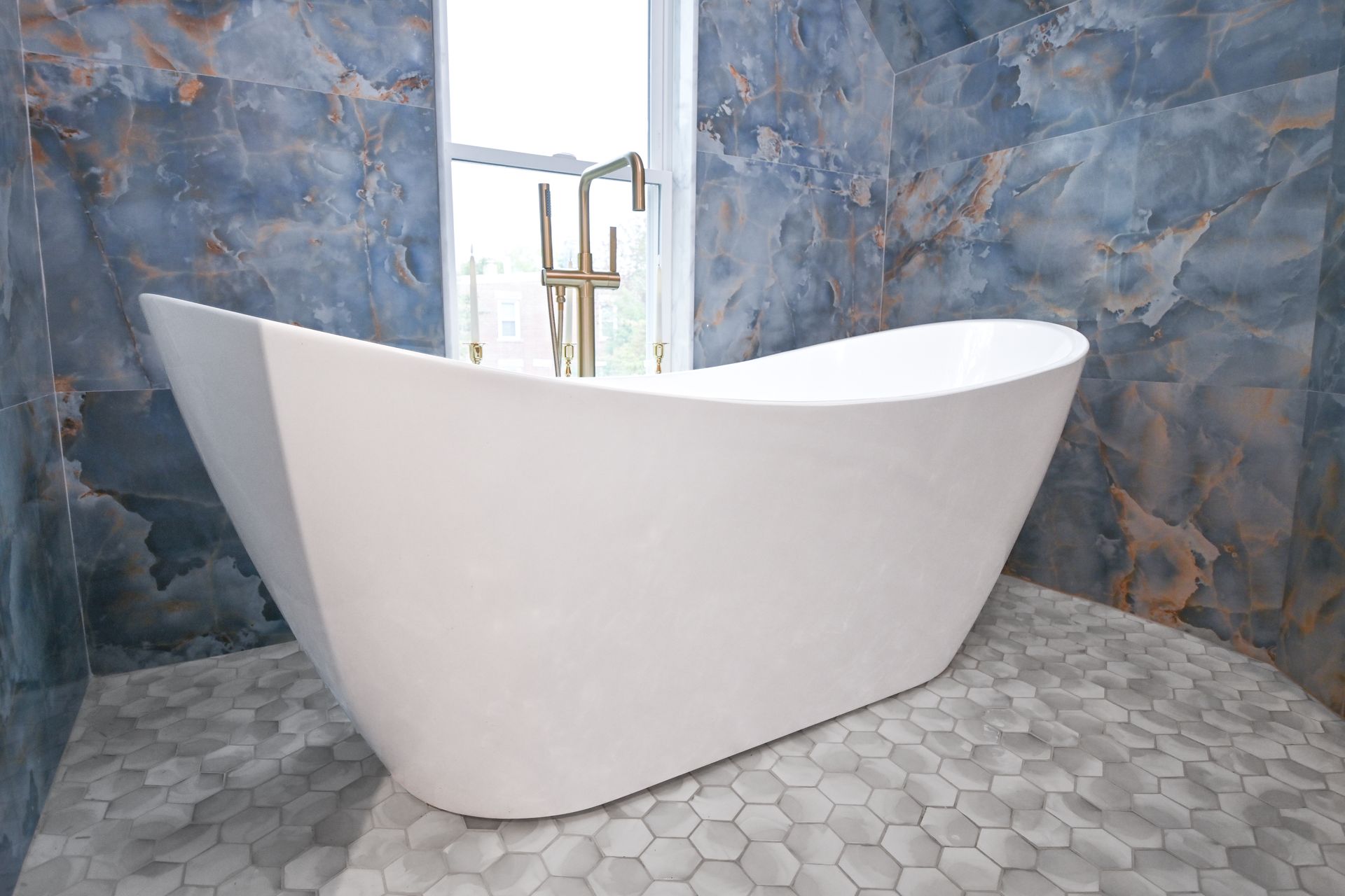 A bathroom with a sink , tub and mirror.