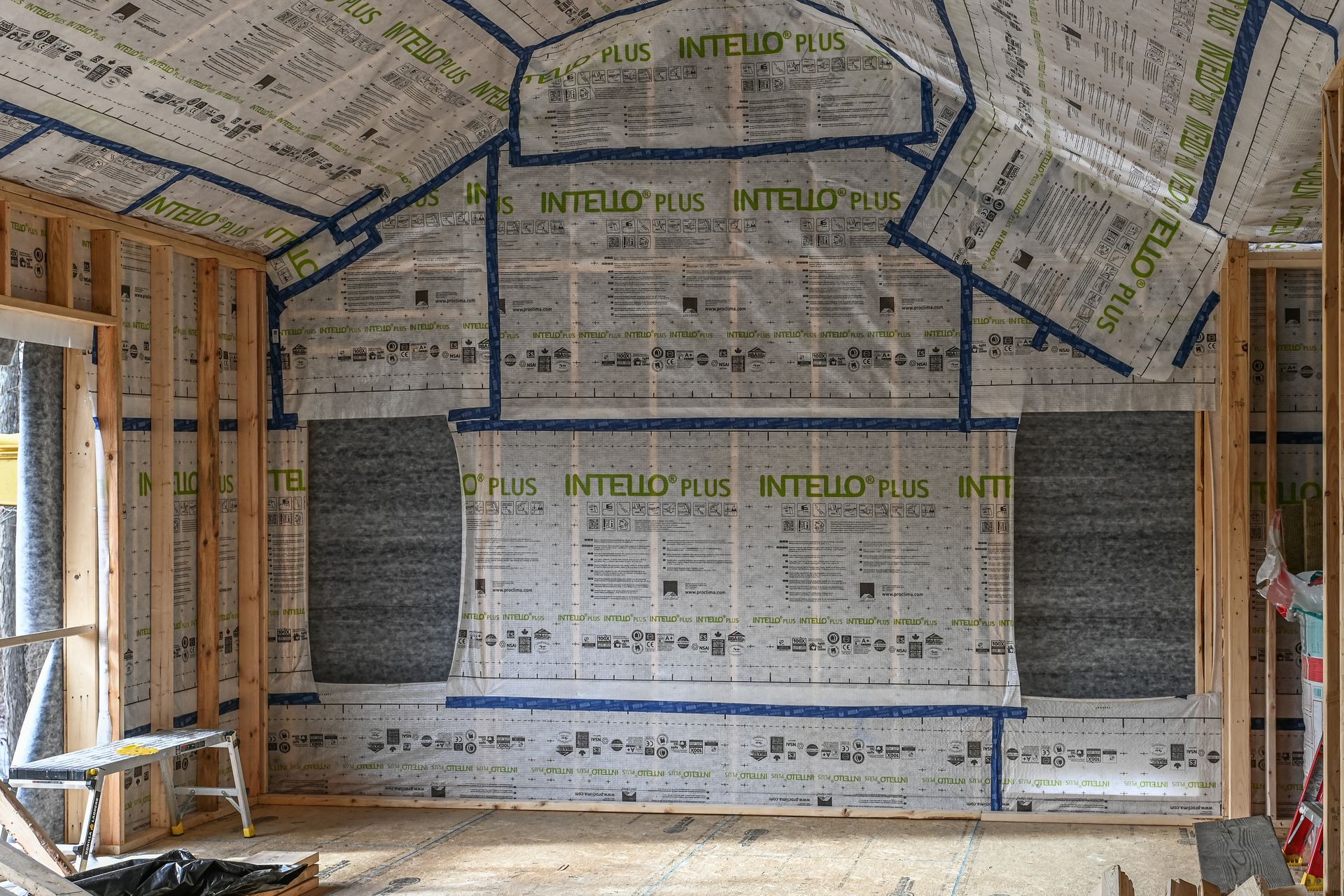 Interior of a building under construction, showing framing, insulation, and vapor barrier.