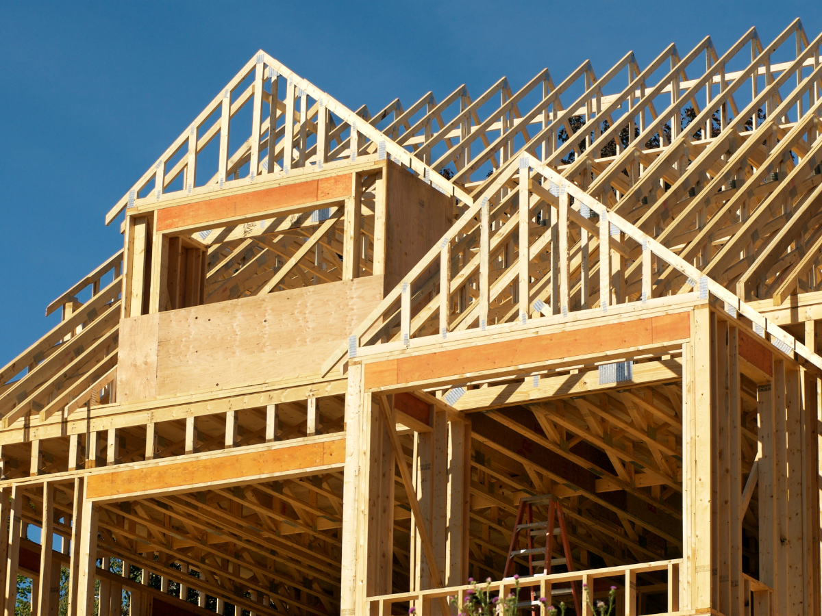 A large wooden house is being built with a blue sky in the background. A large wooden house is being built with a blue sky in the background.