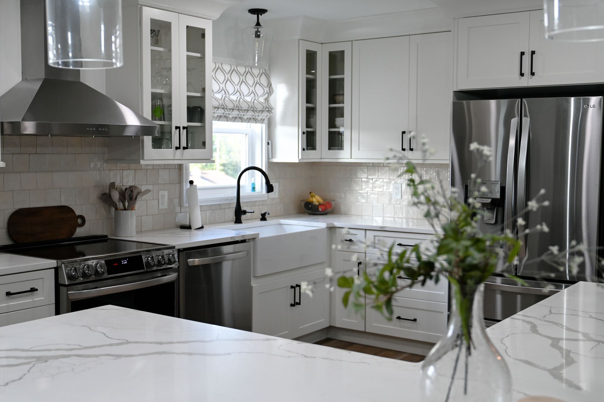 Bright white kitchen with stainless steel appliances, white cabinets, and a marble countertop. Bright white kitchen with stainless steel appliances, white cabinets, and a marble countertop.