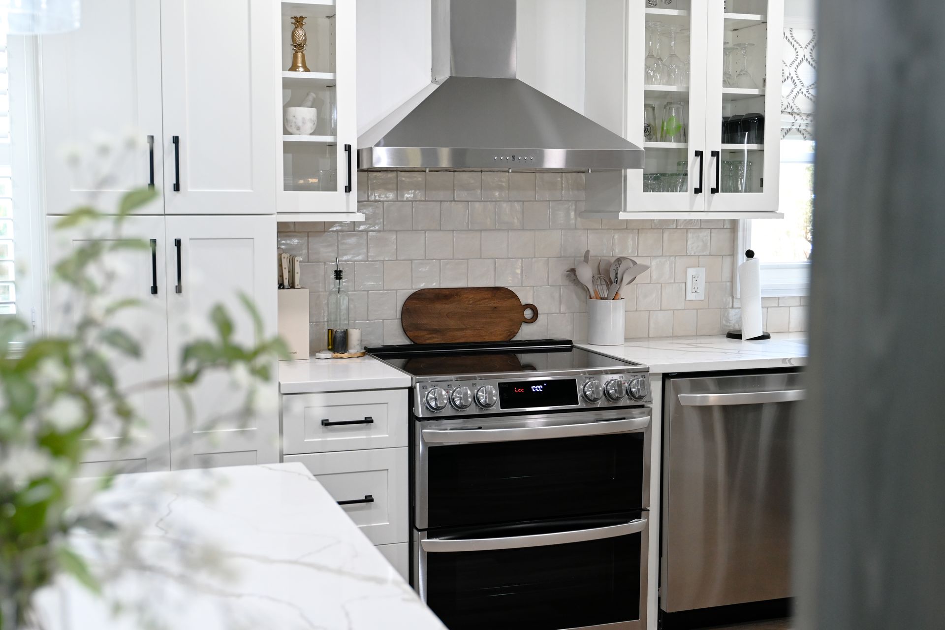 Kitchen with wood floor and green cabinets by WS Design & Build