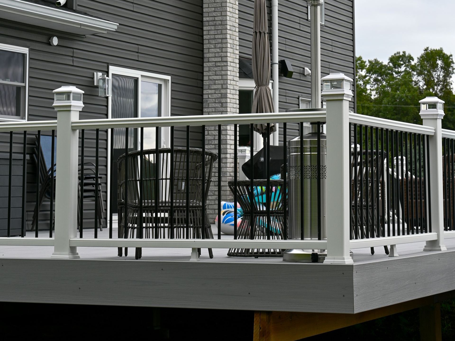 Wooden deck with black railing and potted plants 