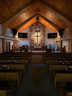 Our beautiful Sanctuary lit with the cross and Jesus, stained glass window.