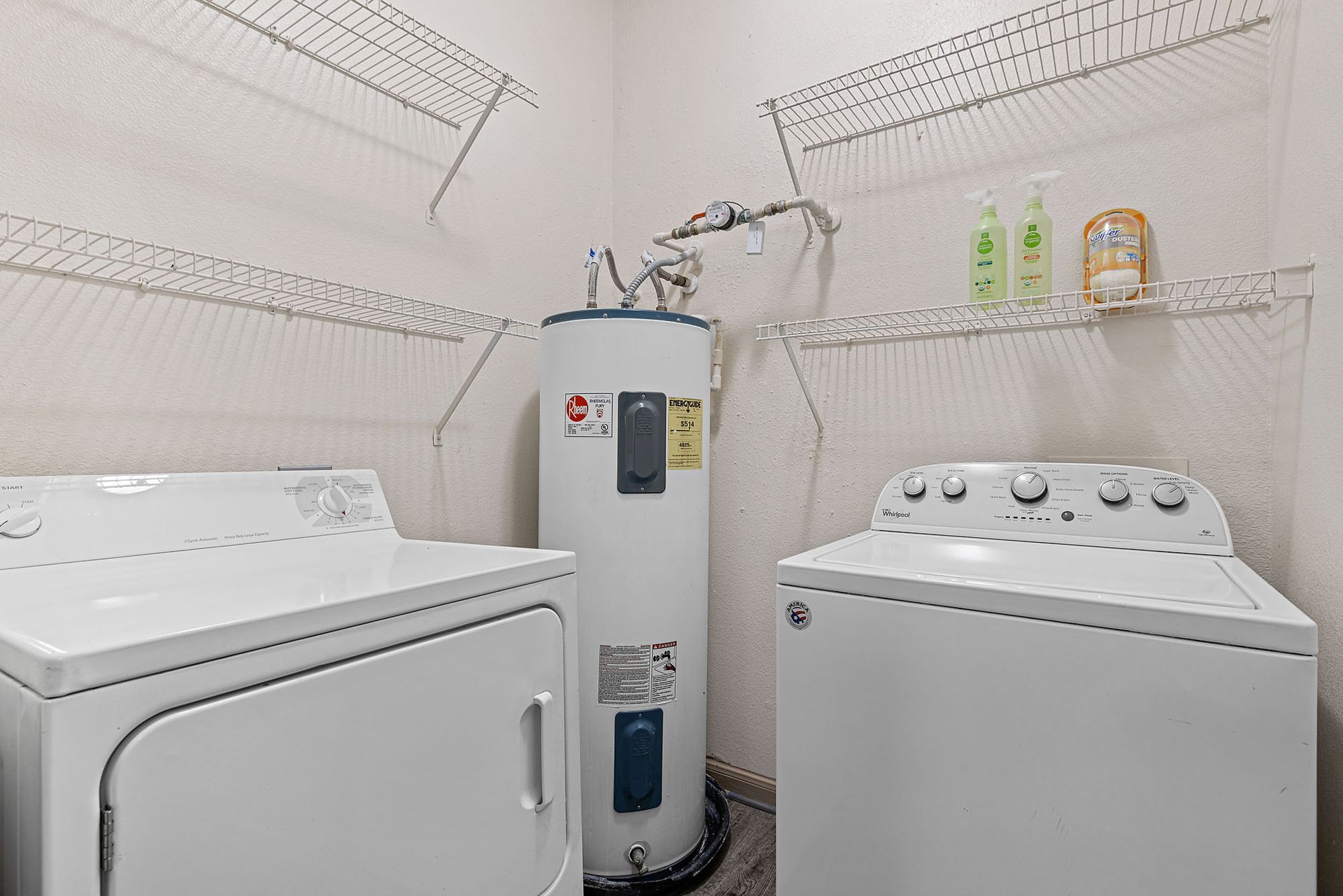 Laundry room with a washer, a dryer, a tall water heater, and wire shelving.