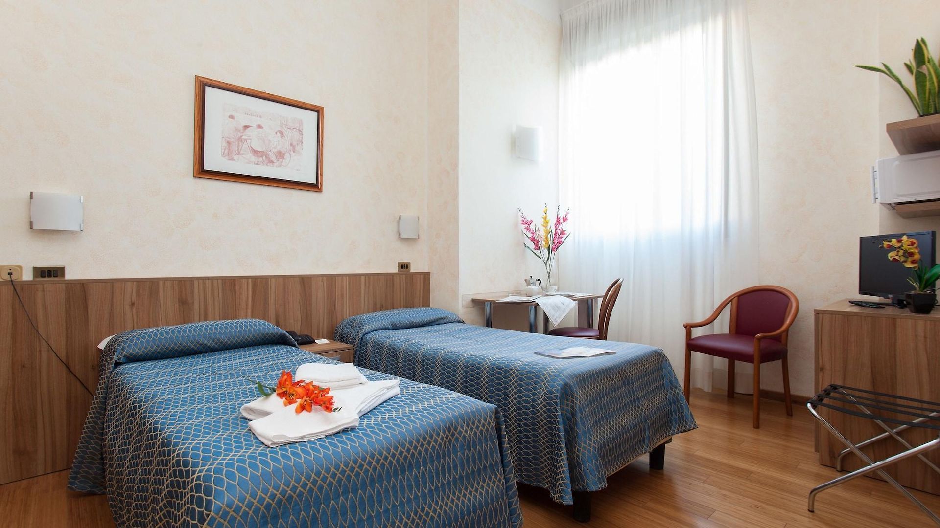 Una camera d'albergo con due letti e una sedia