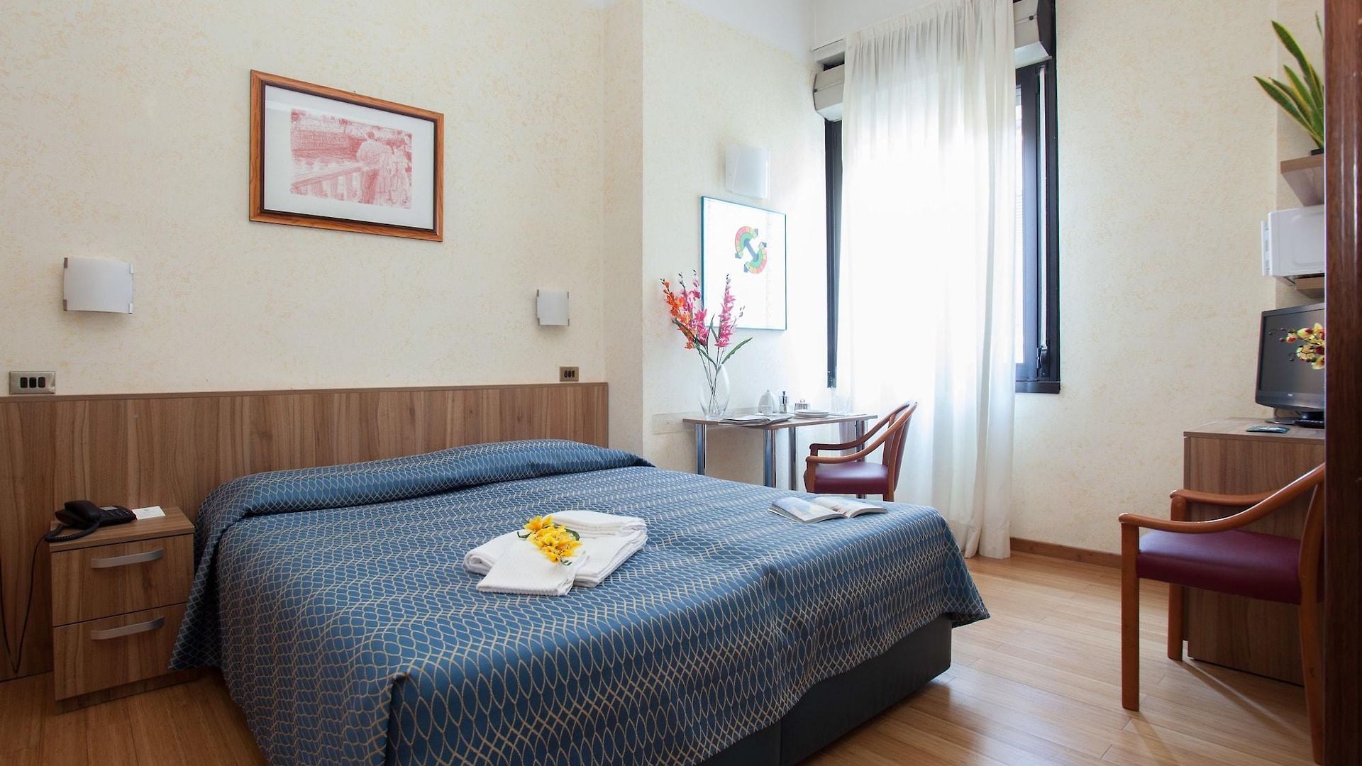 Una camera d'albergo con un letto grande e una sedia