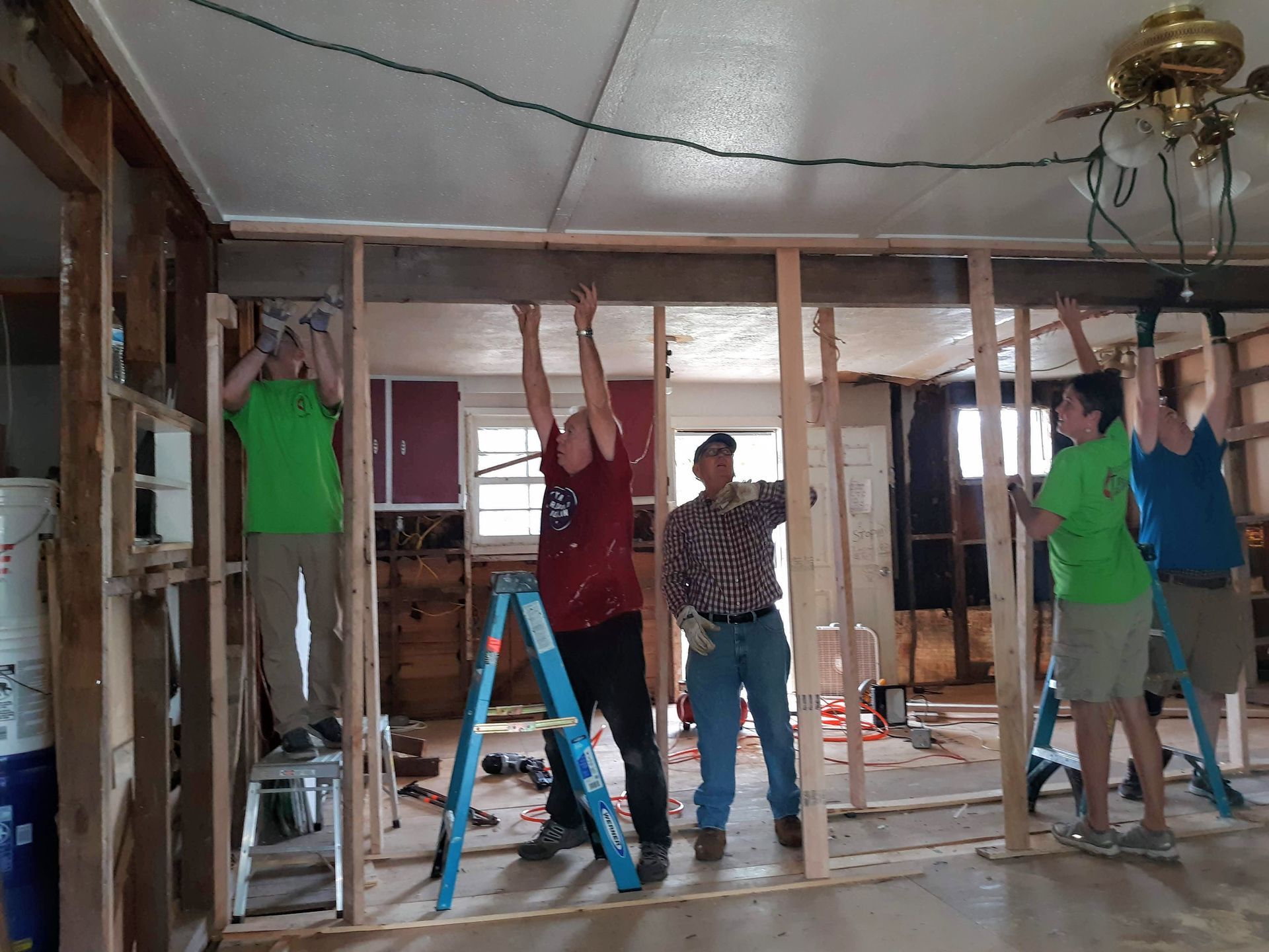 A group of people are working on a house.