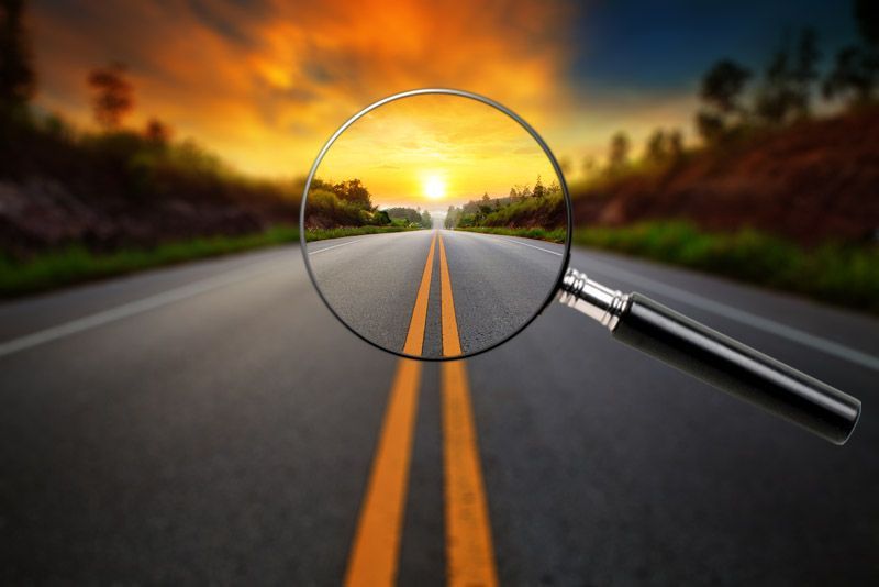 A magnifying glass is looking at a road at sunset.