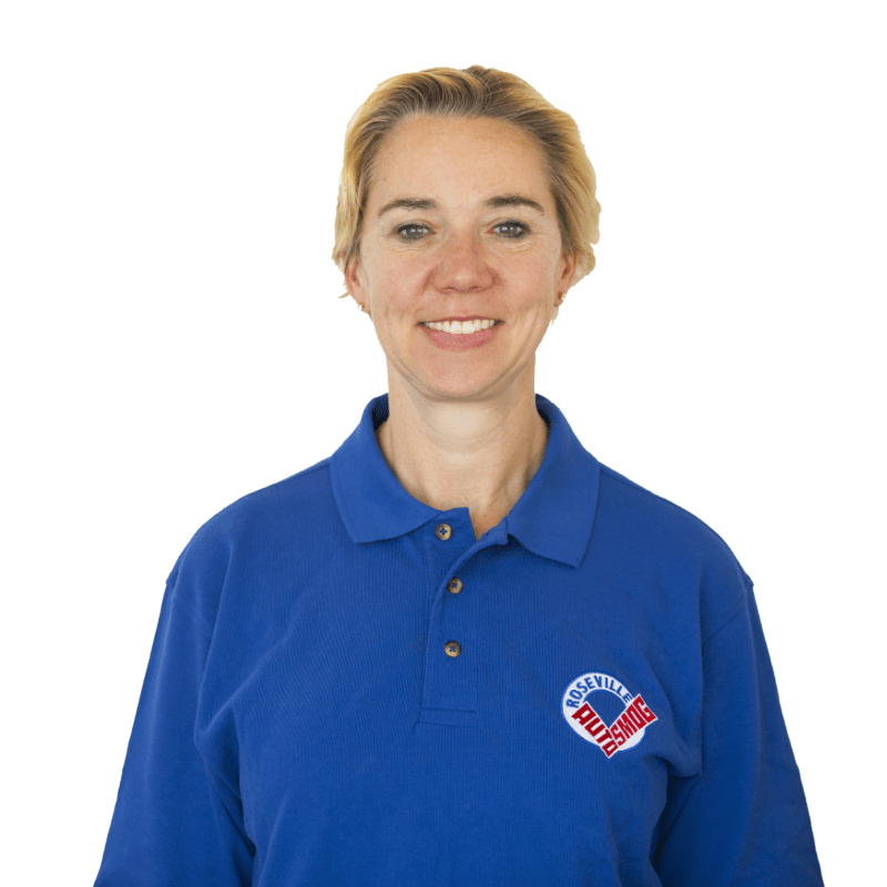 A woman wearing a blue polo shirt with a heart on it. San Juan Auto Smog = woman owned.