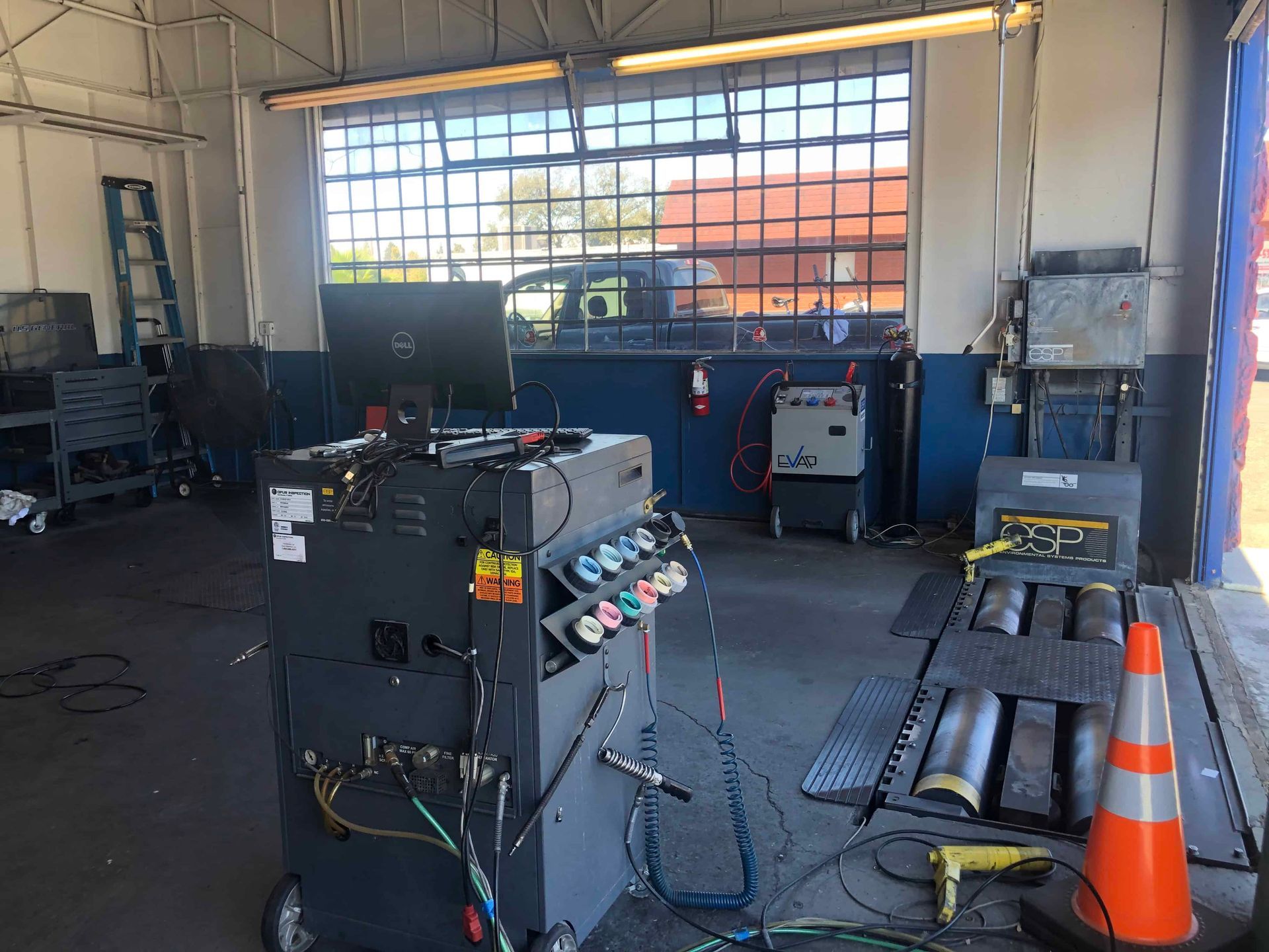 A machine is sitting in a garage next to a cone.