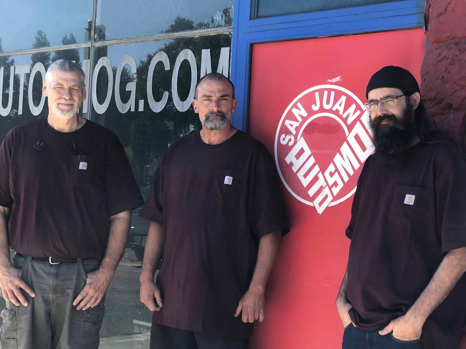 Team photo of three men are standing in front of a sign that says san juan auto smog
