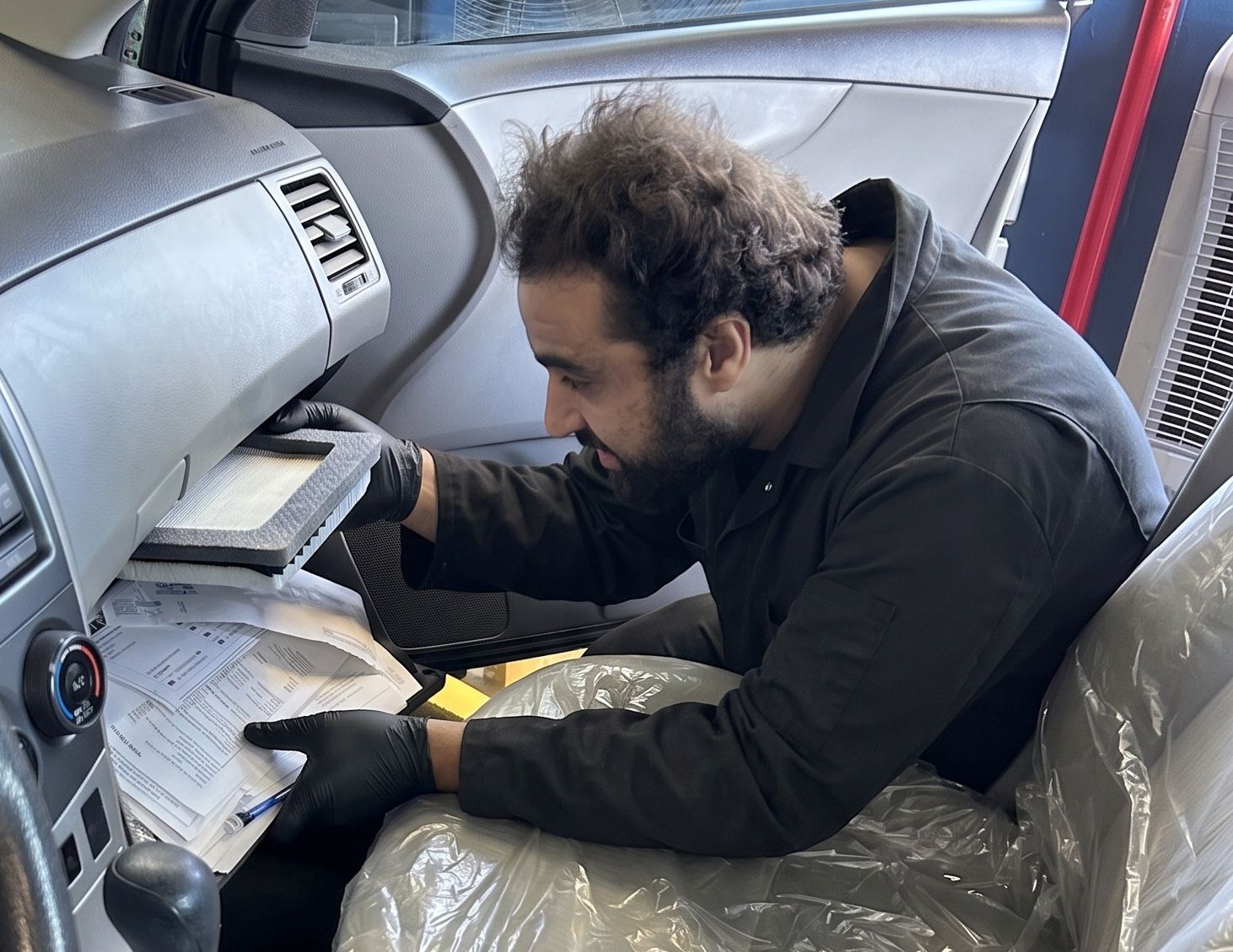 Cabin air filter replacement behind the glove box by a San Juan Auto Smog technician