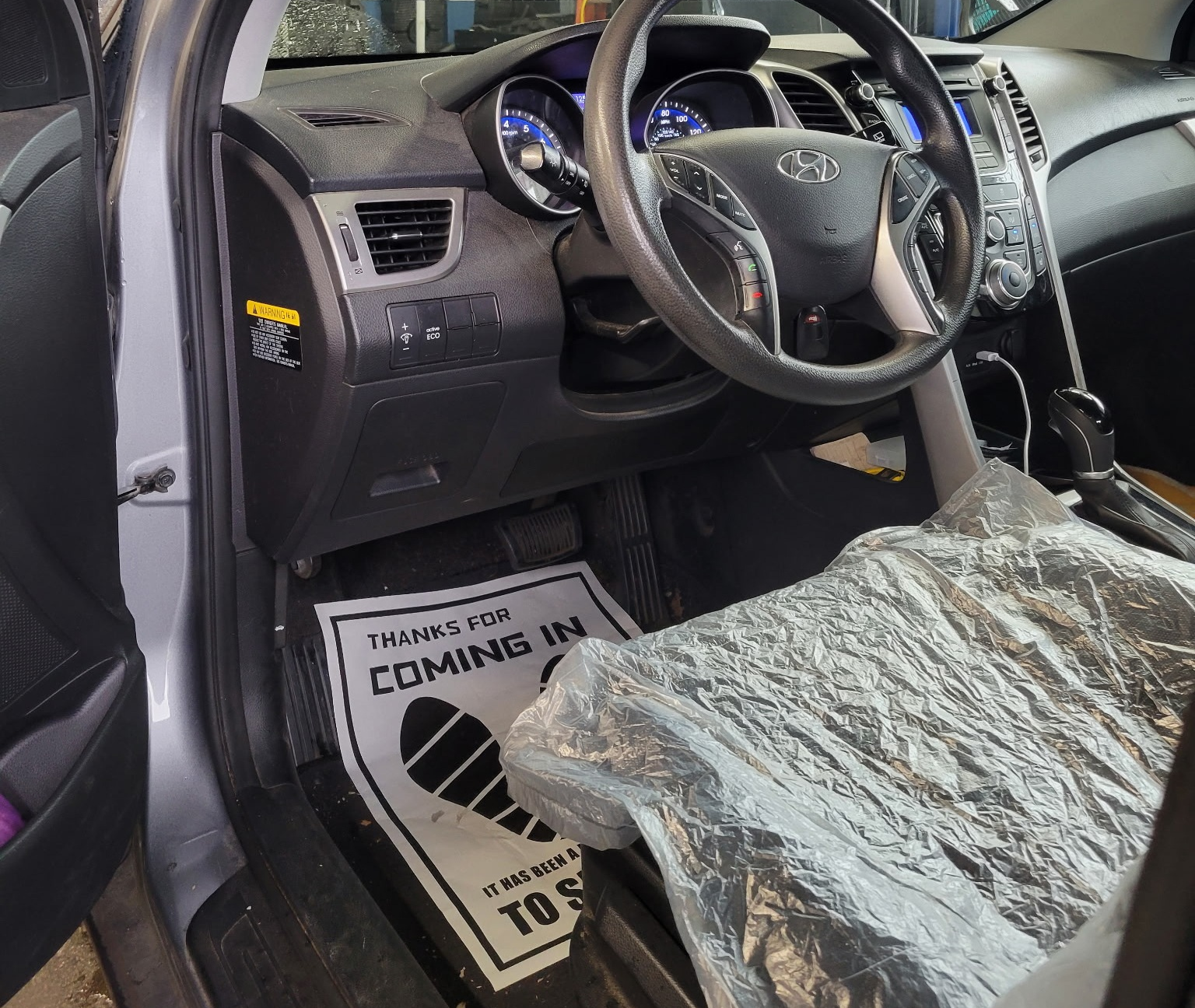 Protective seat cover and floor mat installed during an oil change service