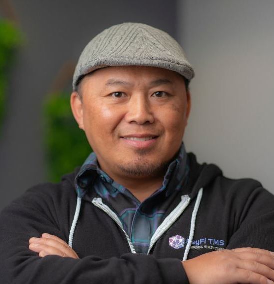 A man wearing a hat and a hoodie with the word tms on it