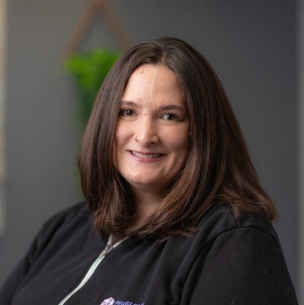 A woman in a black shirt is smiling for the camera.