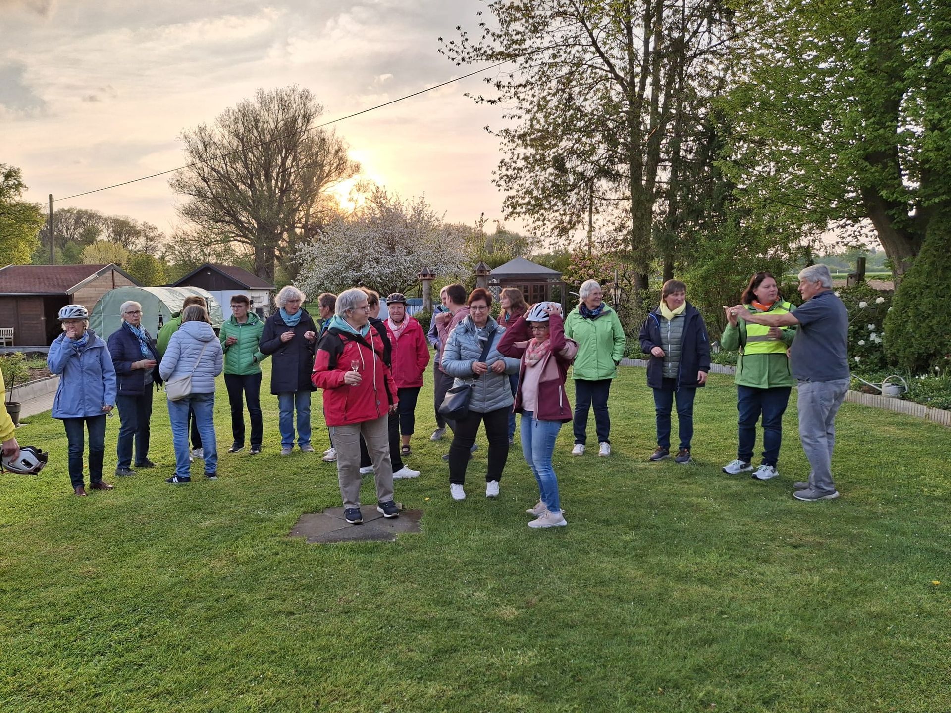 Eine Gruppe von Menschen steht auf einer Wiese.