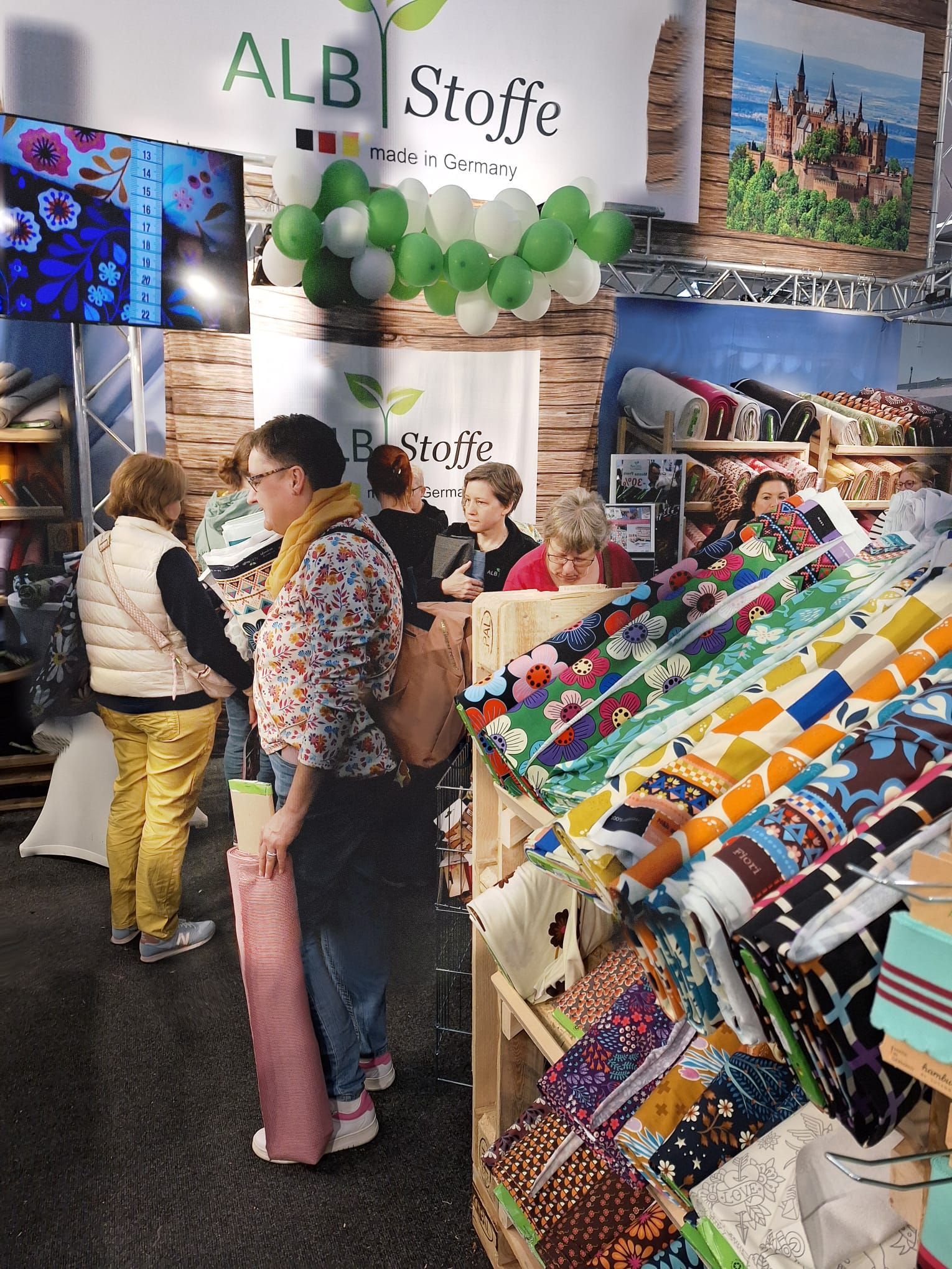 Eine Gruppe von Menschen steht vor einer Stoffausstellung.