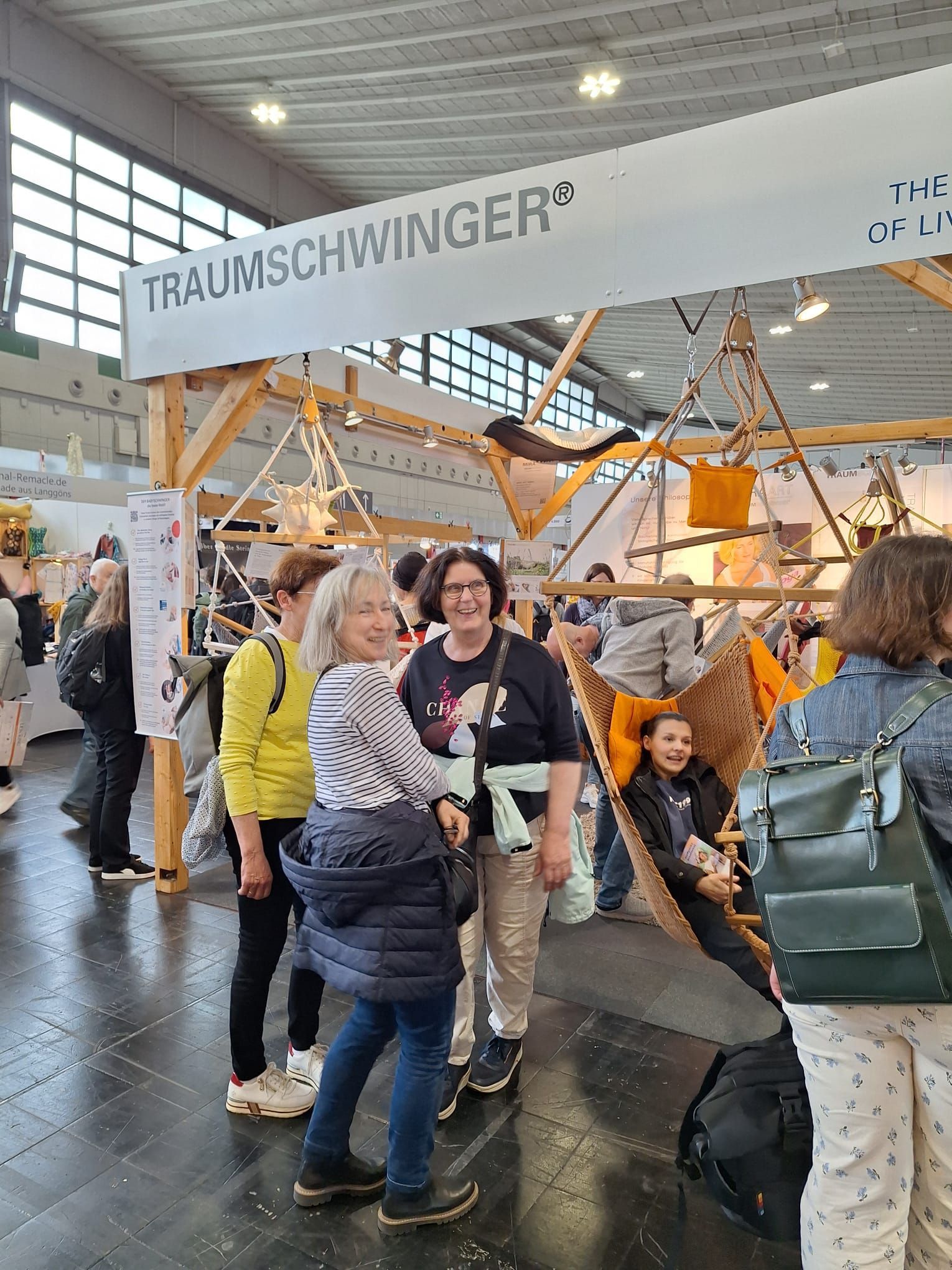 Bei einer Tagung steht eine Gruppe von Menschen in einem Raum.