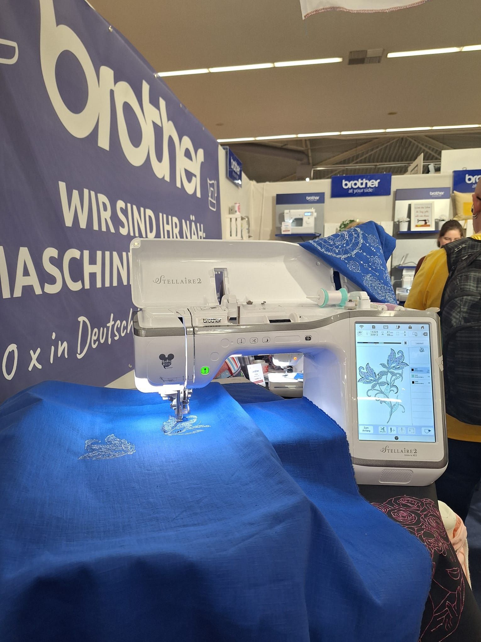 Eine Nähmaschine vor einem Banner mit der Aufschrift „Bruder“