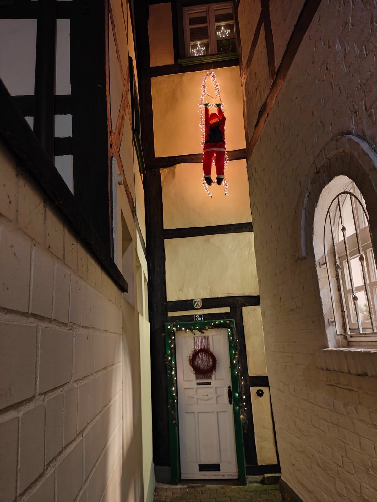 Eine schmale Gasse mit einem Weihnachtsmann, der von der Decke hängt
