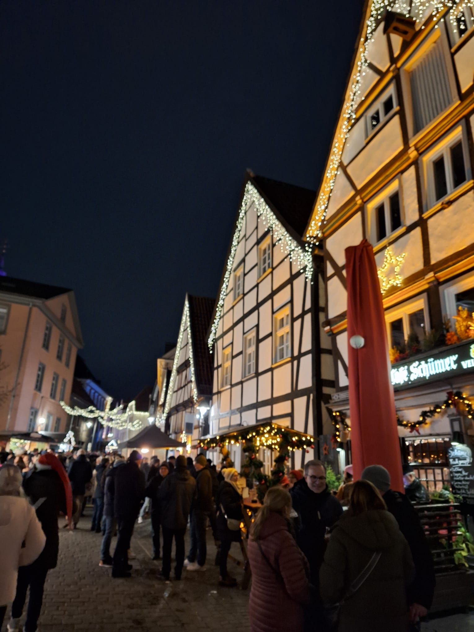 Eine Gruppe von Menschen steht vor einem Gebäude mit einem Schild mit der Aufschrift „Restaurant“