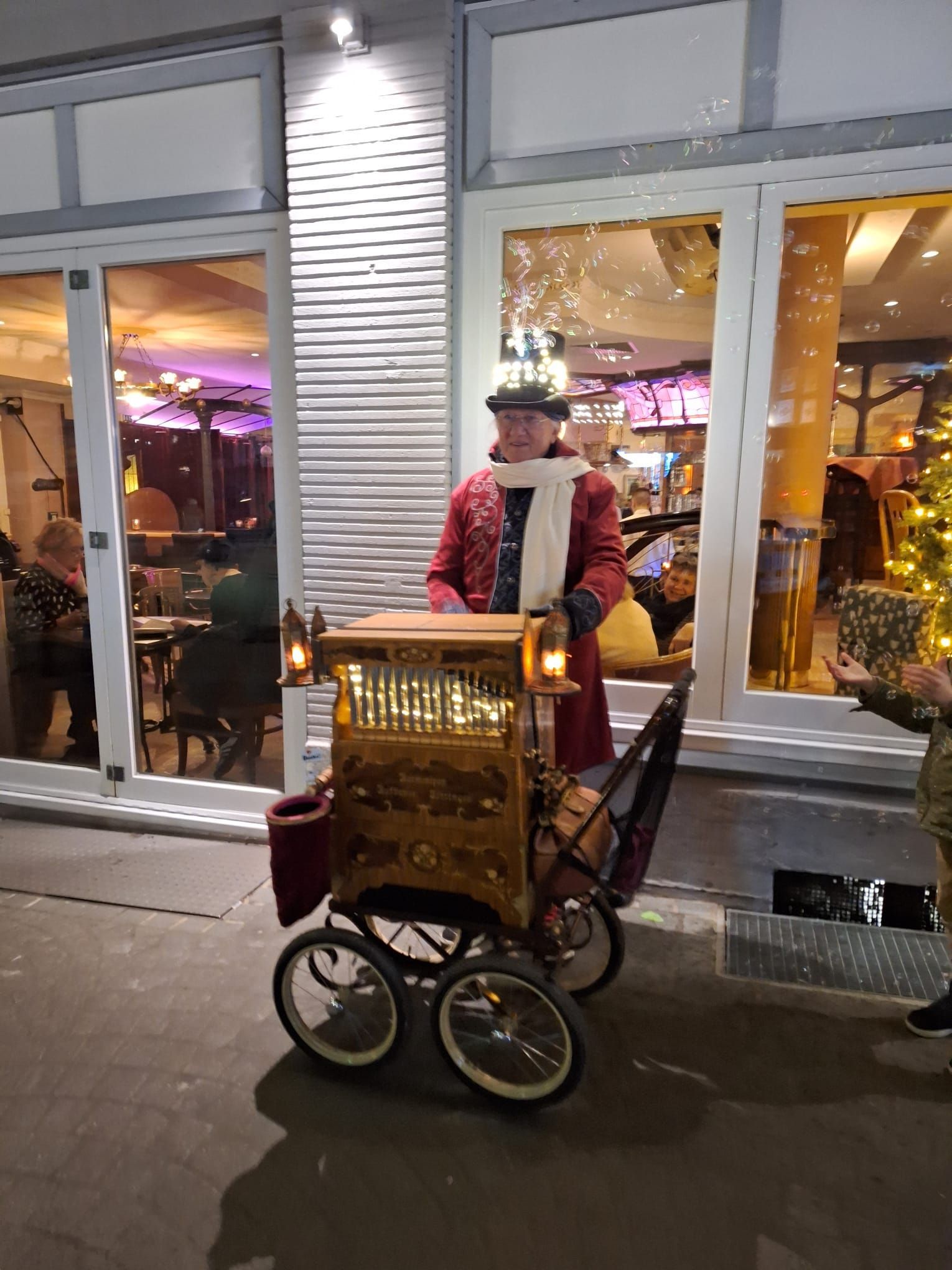 Ein Mann spielt vor einem Gebäude ein Musikinstrument.