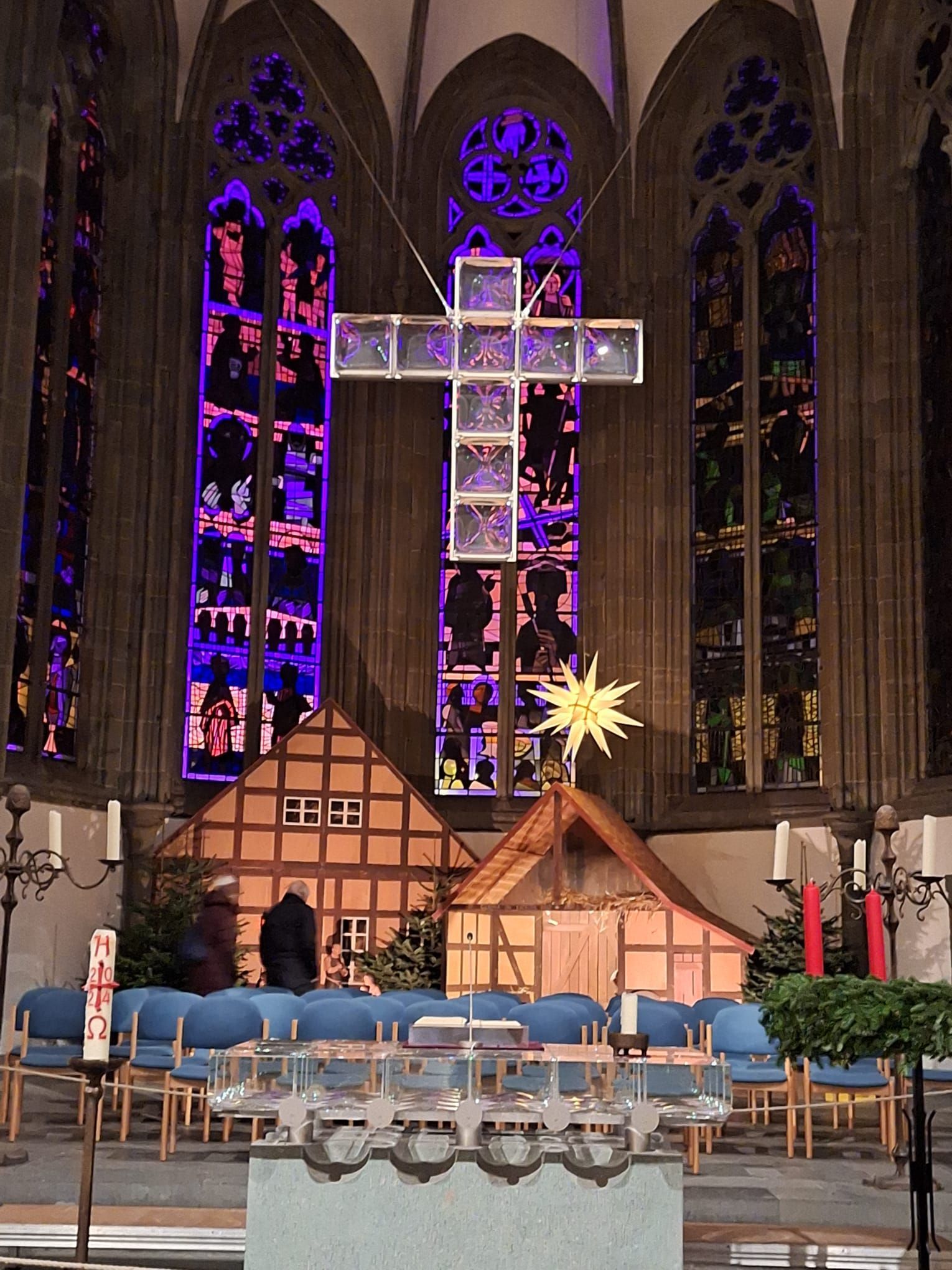Ein großes Kreuz hängt von der Decke einer Kirche