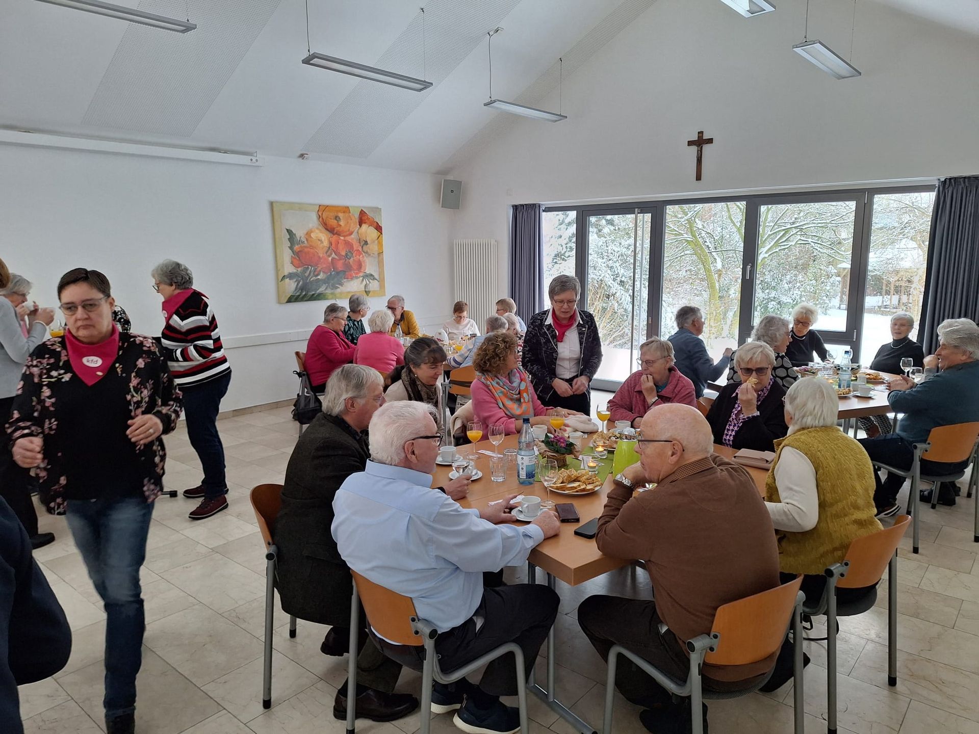 Eine Gruppe von Menschen sitzt in einem Raum an Tischen.