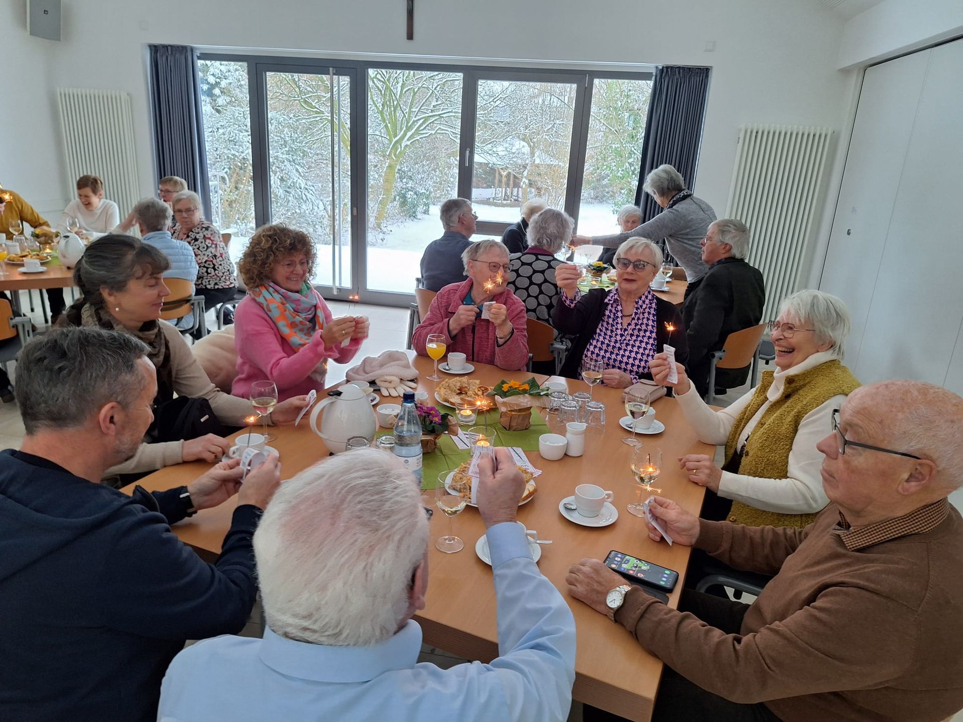 Eine Gruppe von Menschen sitzt um einen Tisch herum und isst und trinkt.