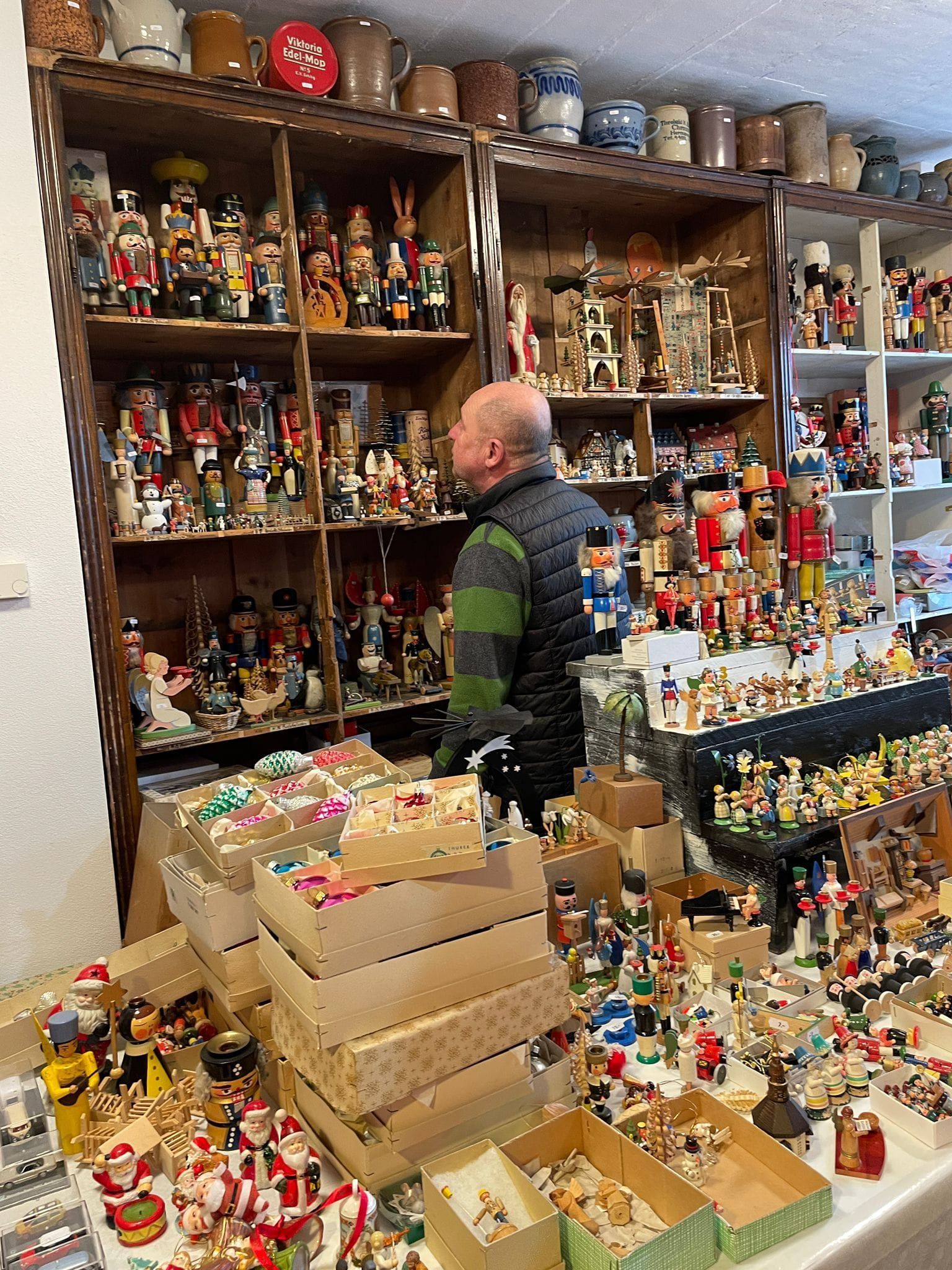 Ein Mann steht vor einem Regal voller Nussknacker.