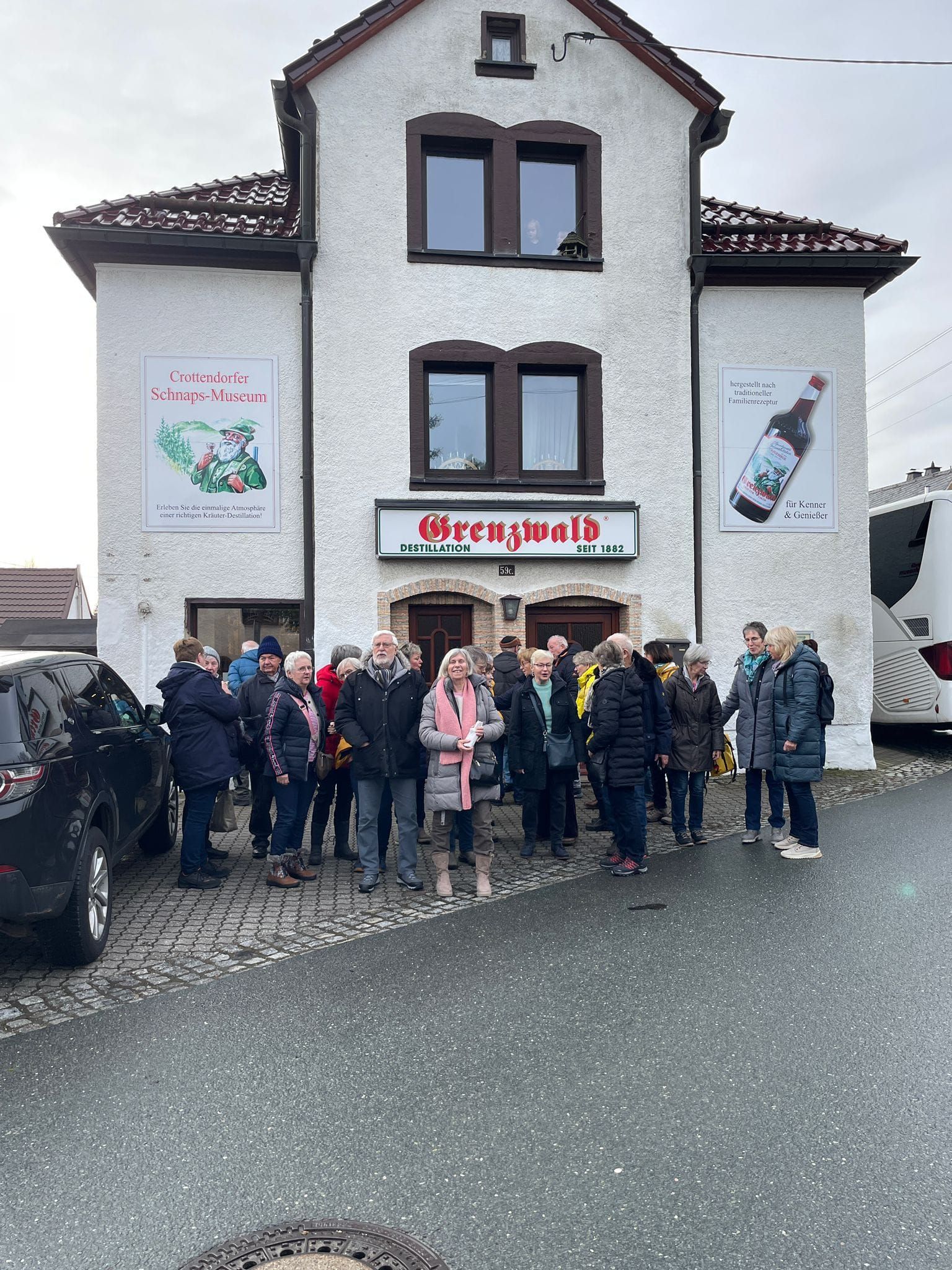 Eine Gruppe von Menschen steht vor einem Gebäude.