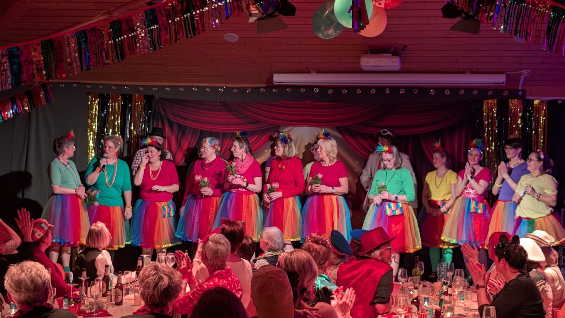 Eine Gruppe von Menschen steht vor einer Menschenmenge auf einer Bühne.