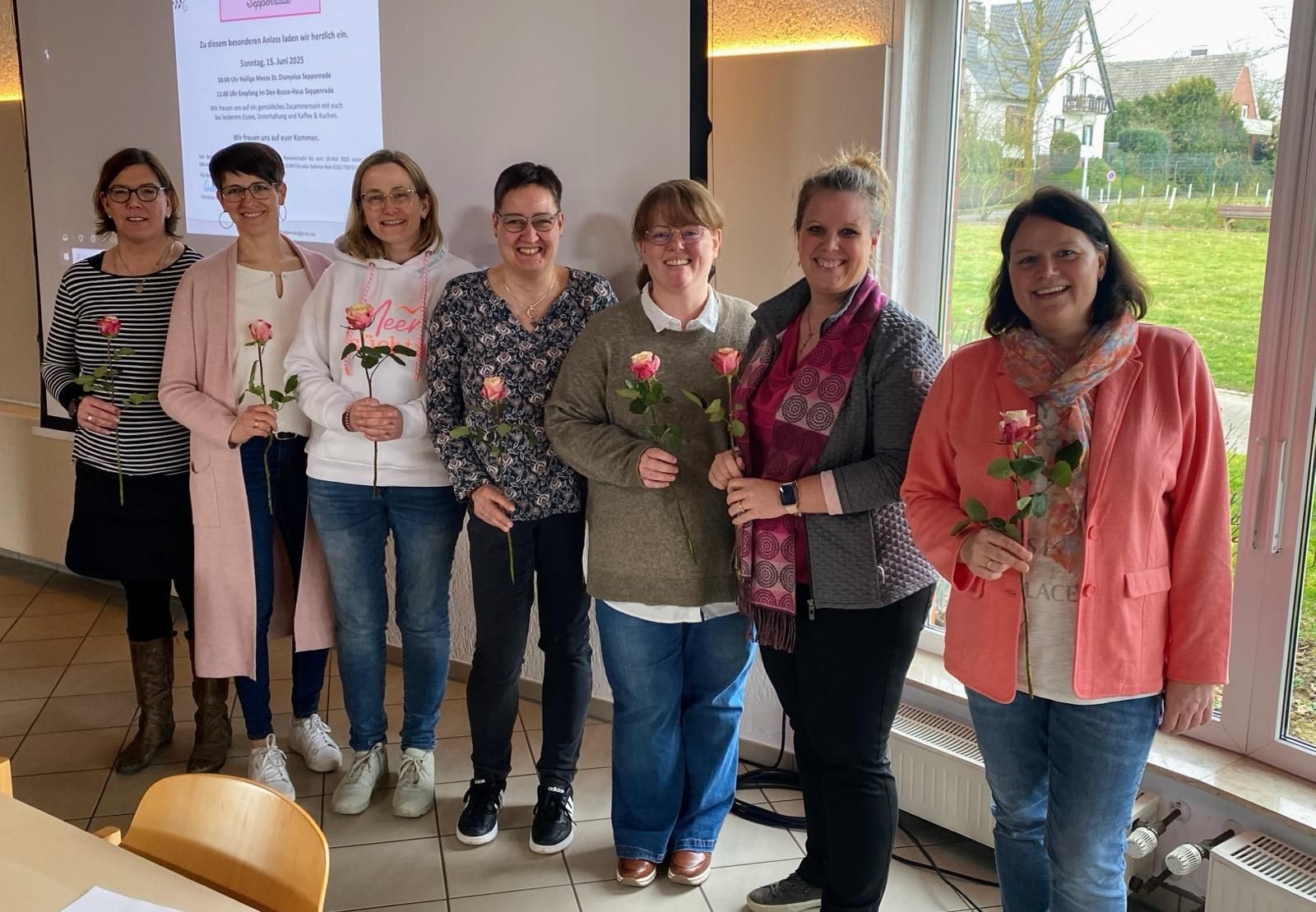 Eine Gruppe von Frauen steht nebeneinander und hält Blumen in den Händen.