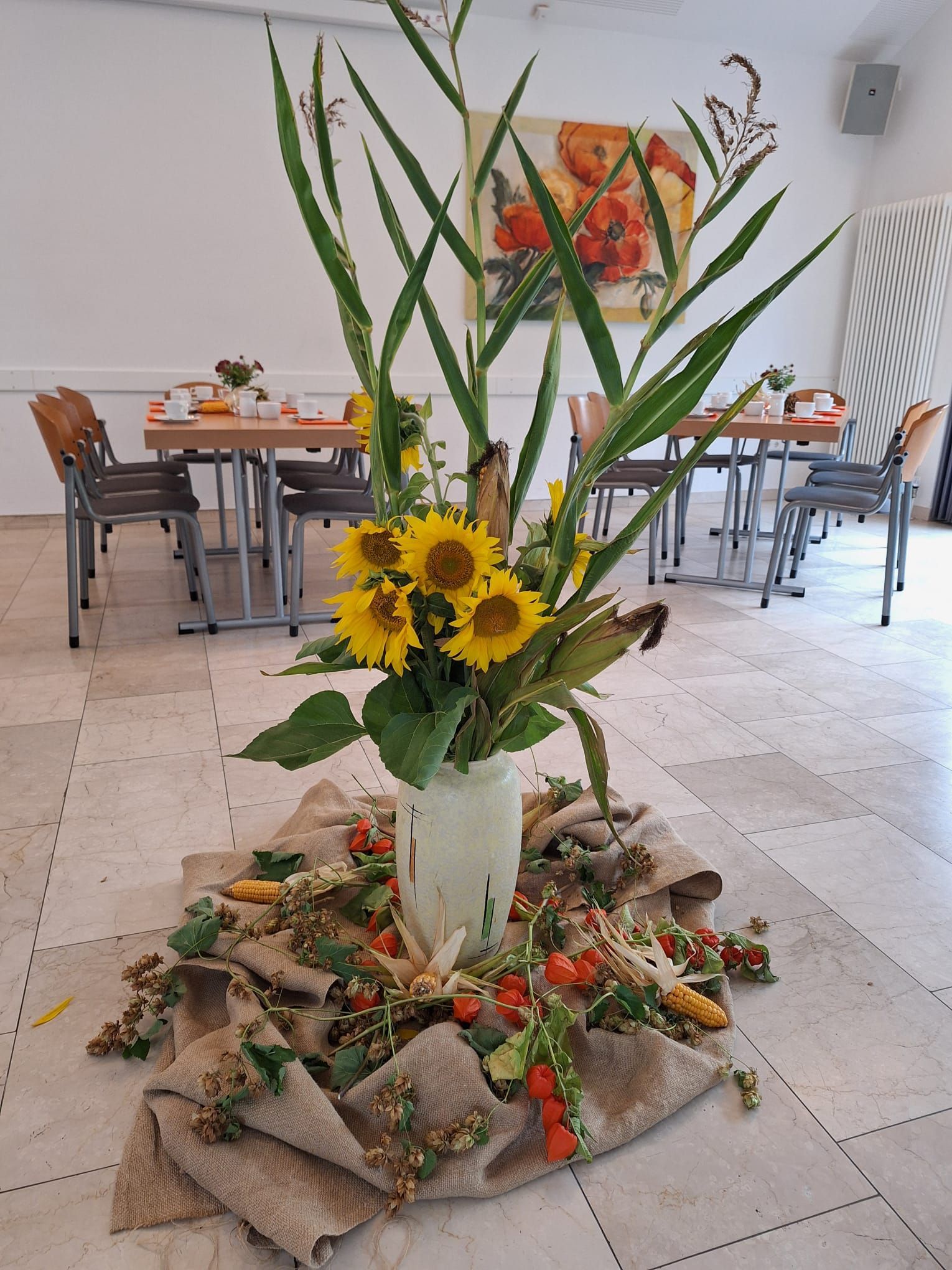 Eine mit Blumen gefüllte Vase steht auf dem Boden in einem Raum