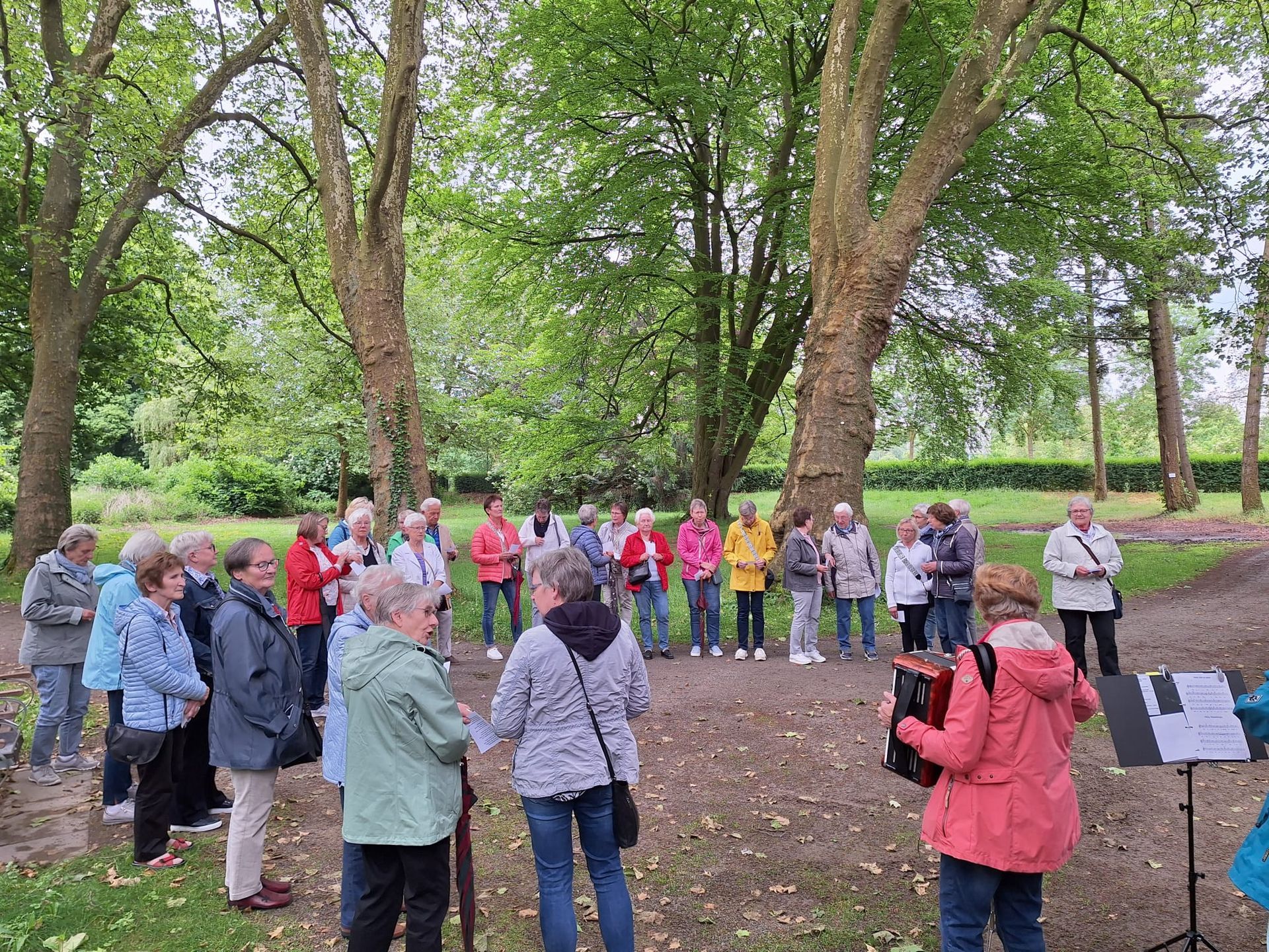 Eine Gruppe von Menschen steht in einem Park.