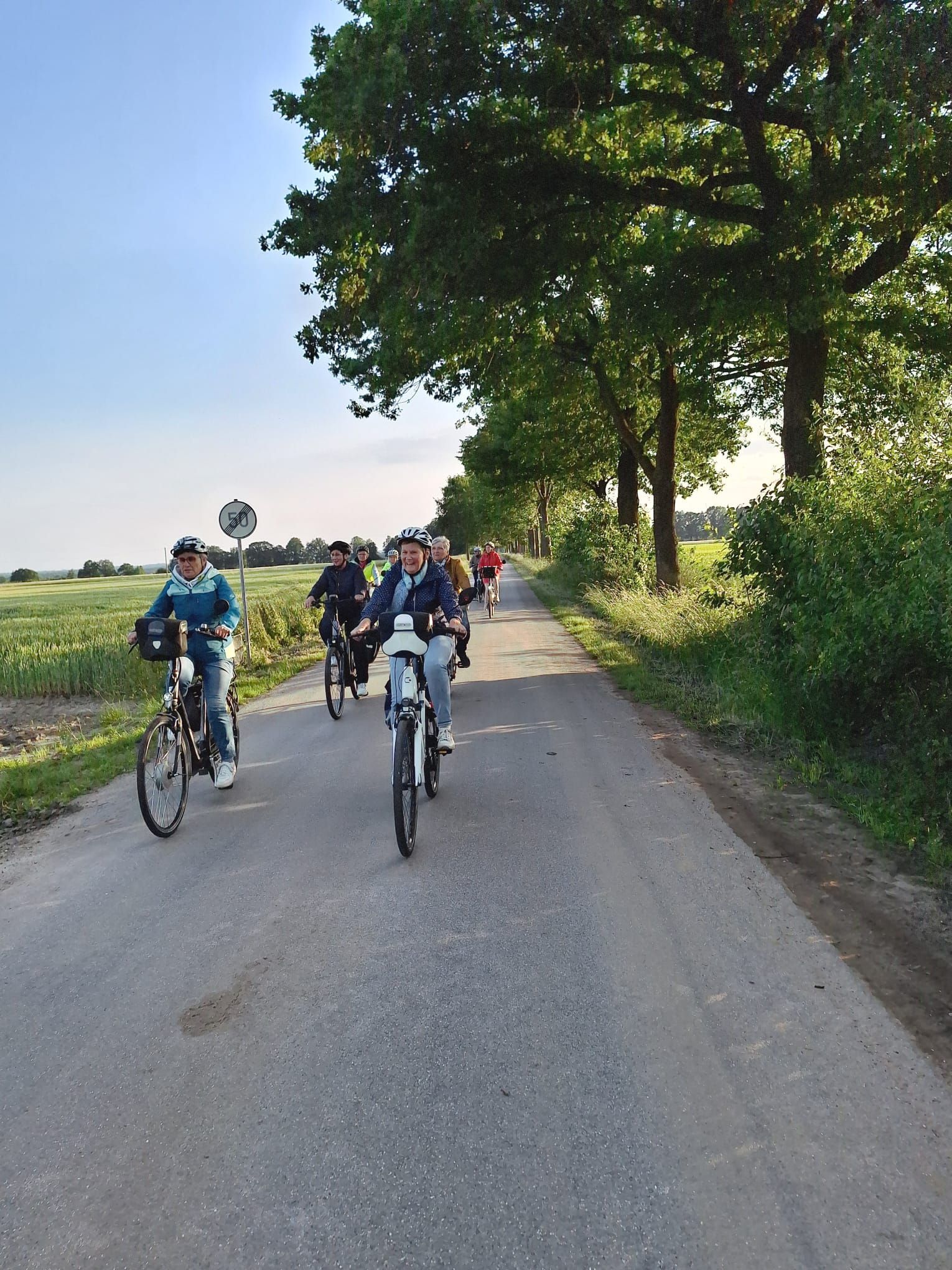 Eine Gruppe von Menschen fährt mit dem Fahrrad eine Straße entlang