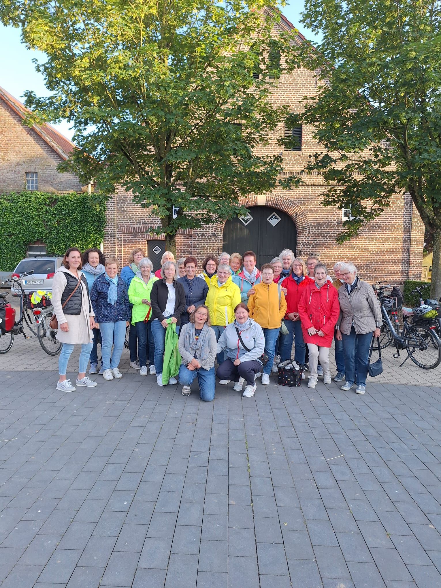 Eine Gruppe von Menschen posiert vor einem Gebäude für ein Foto.