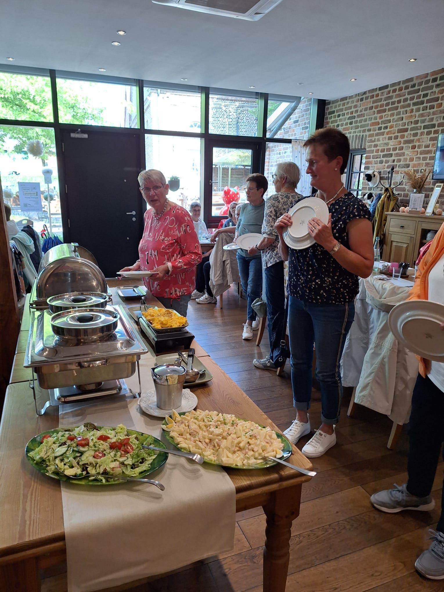 Eine Gruppe von Menschen steht um einen Tisch herum und isst.