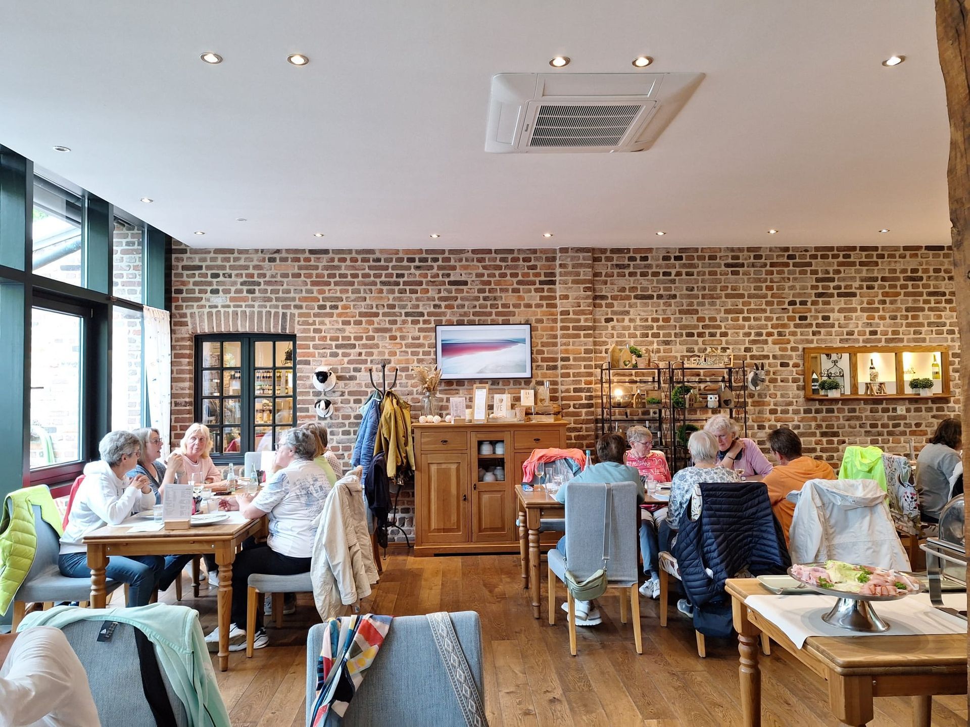Eine Gruppe von Menschen sitzt in einem Restaurant an Tischen.