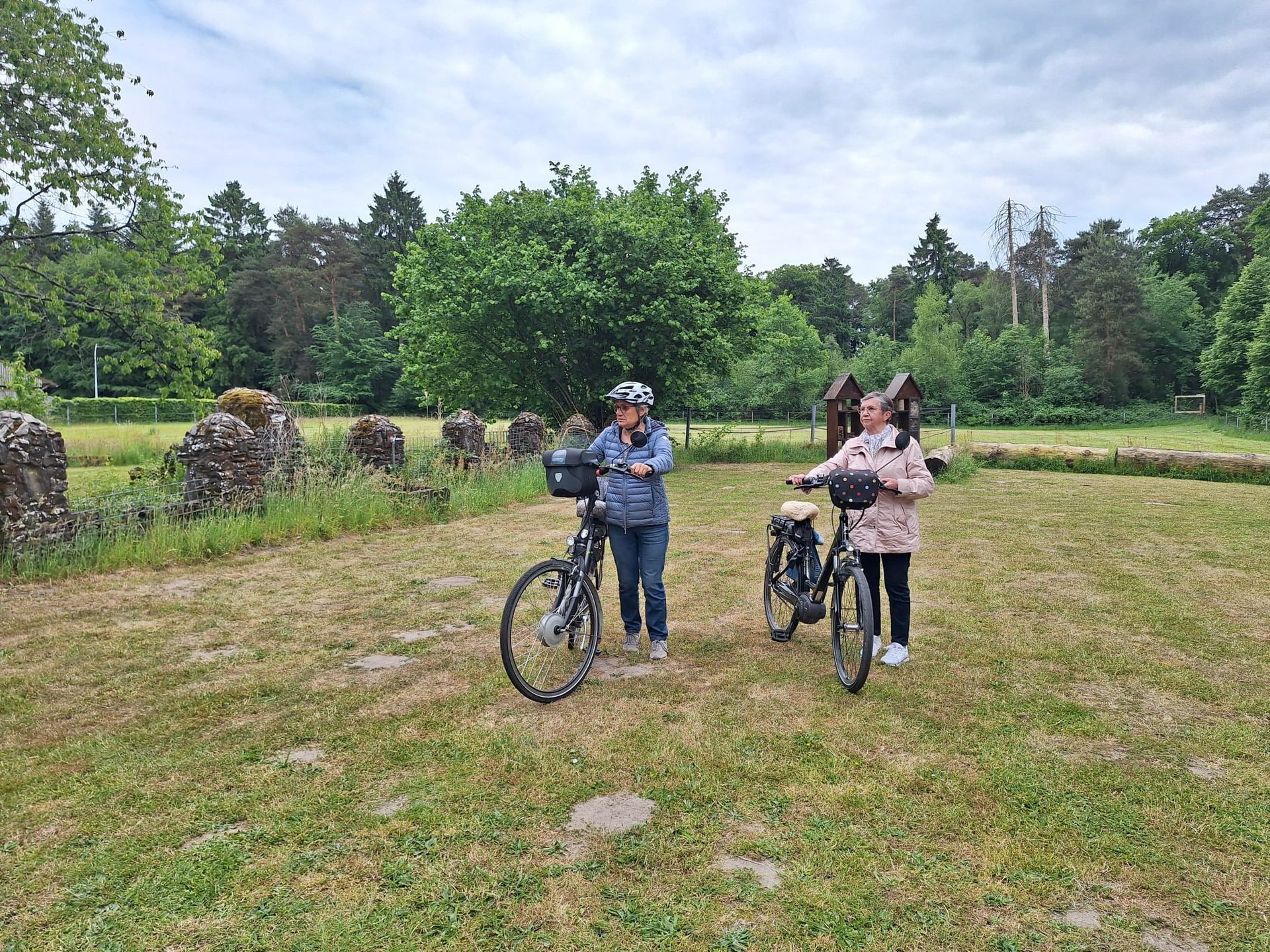 Ein Mann und eine Frau stehen neben Fahrrädern auf einem Feld.