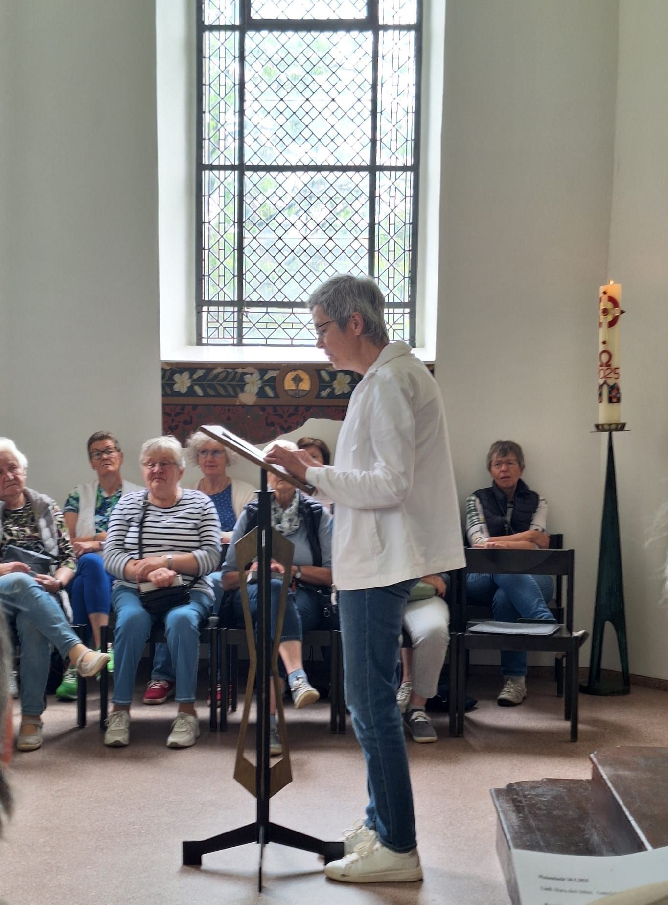 Eine Frau steht in einer Kirche vor einem Mikrofon.