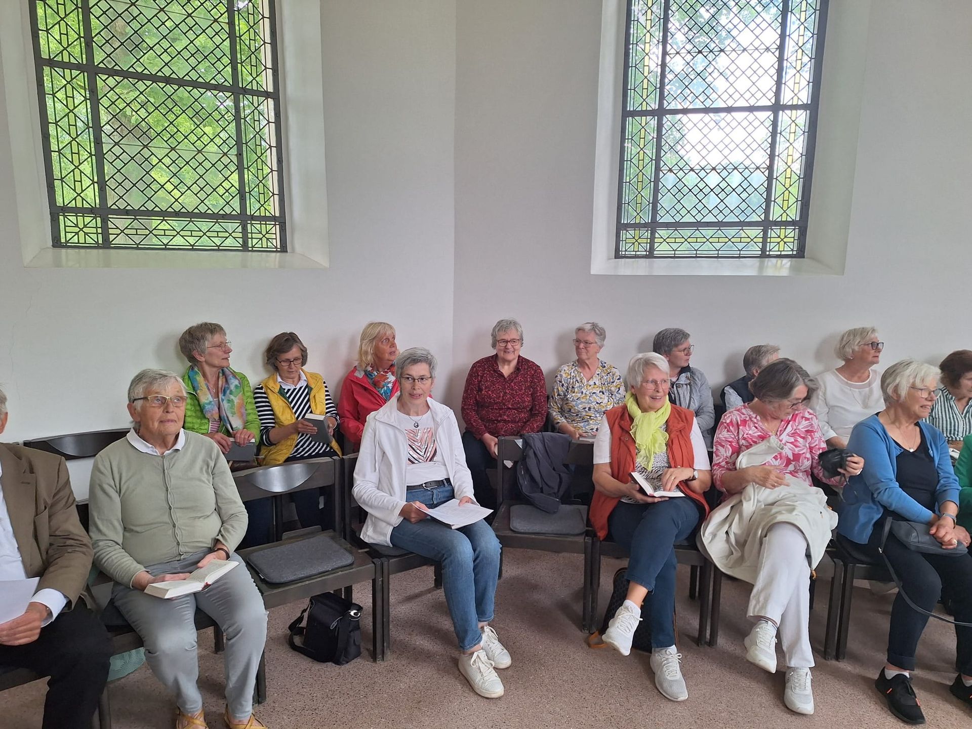 Eine Gruppe von Menschen sitzt auf Stühlen in einem Raum.